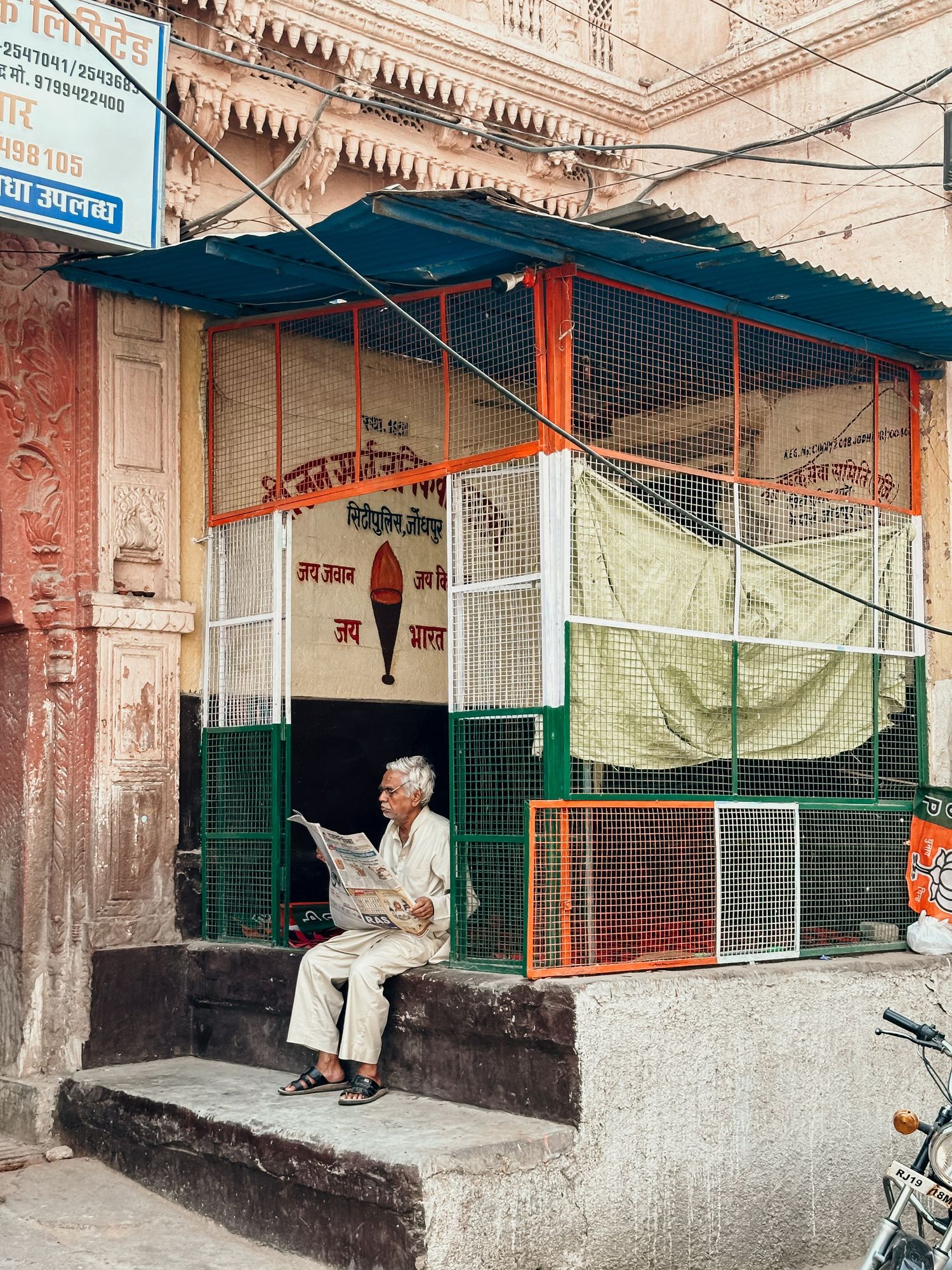 En indisk man som läser en tidning på gatorna i Jodhpur