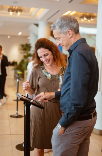 Business professionals interacting with digital devices in modern office lobby.