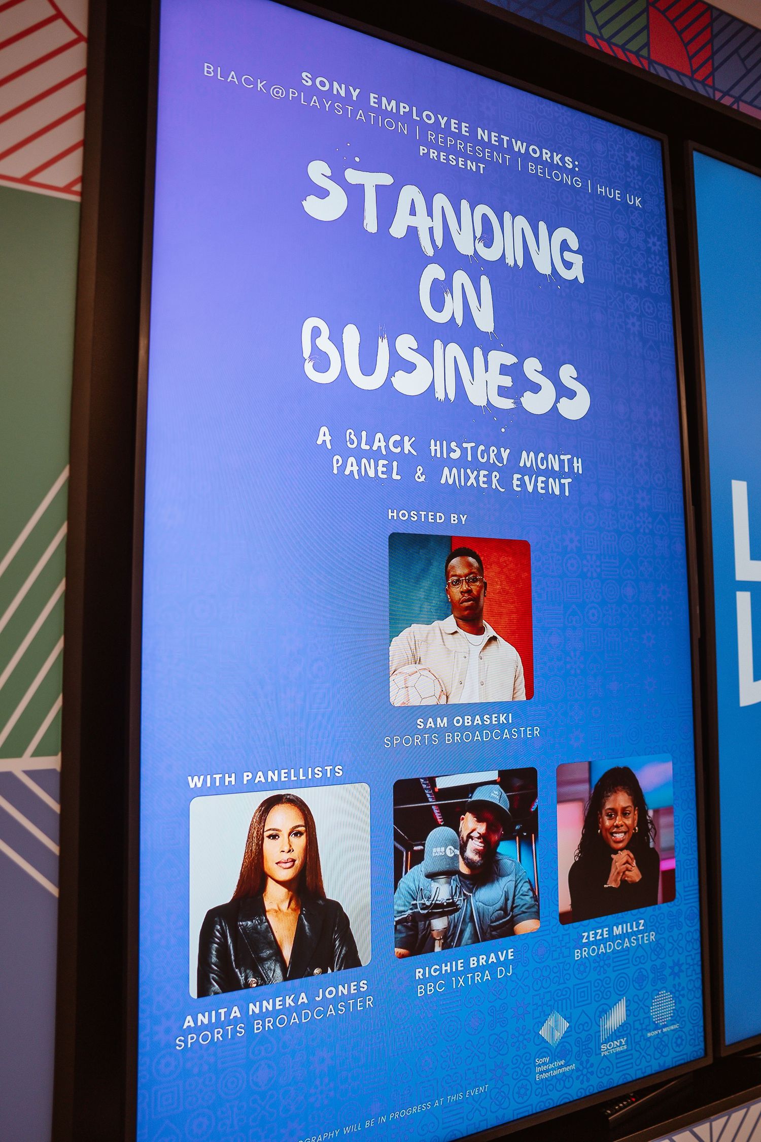 Digital display showing 'Standing Business' event panel with speaker headshots.