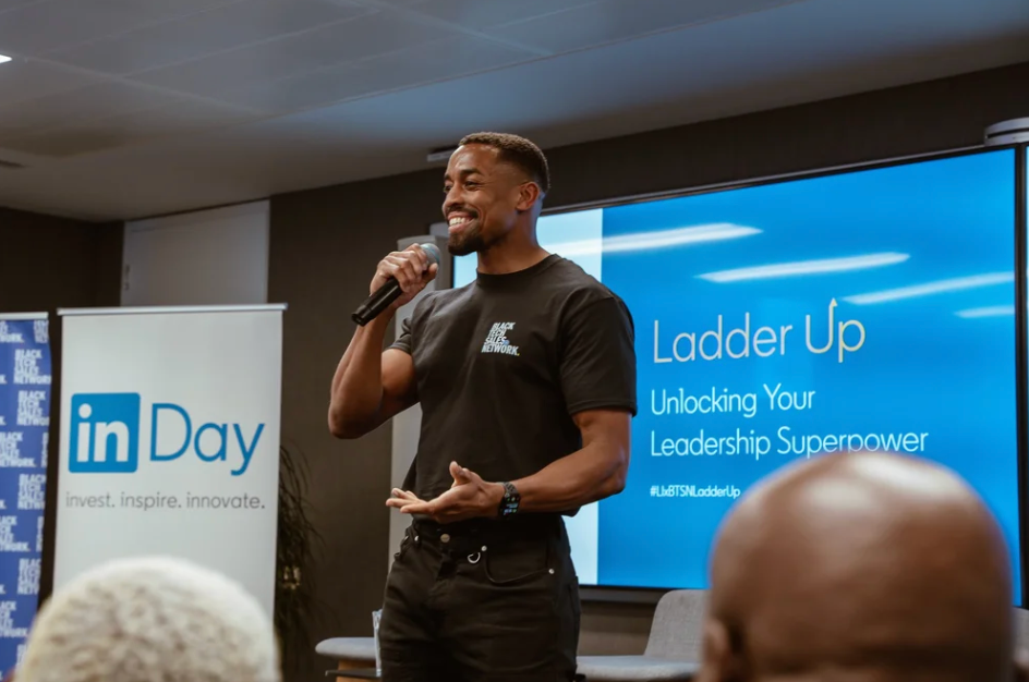 Professional speaker presenting at LinkedIn corporate event with blue branding.