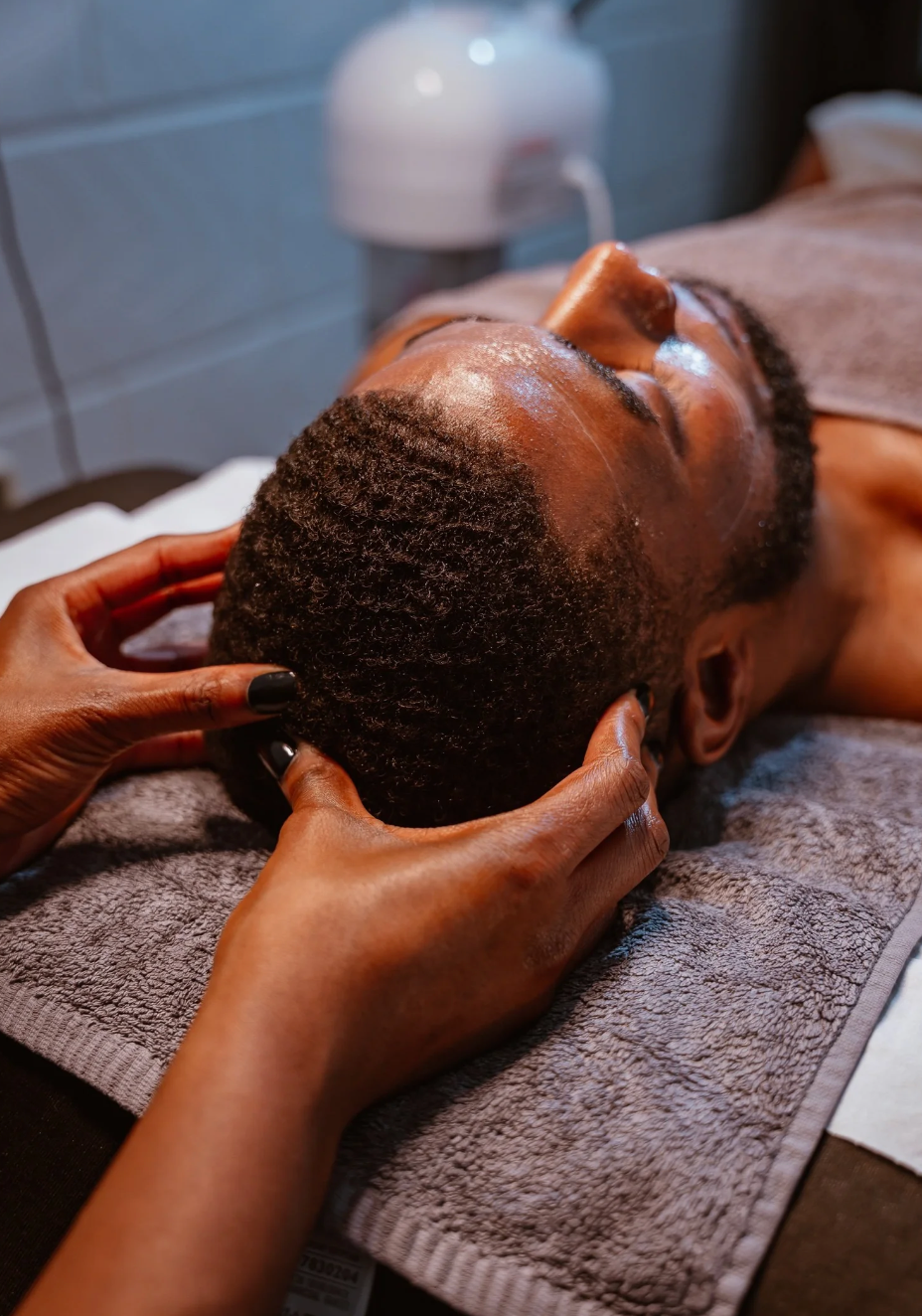 Client receiving a relaxing facial massage treatment at a spa.