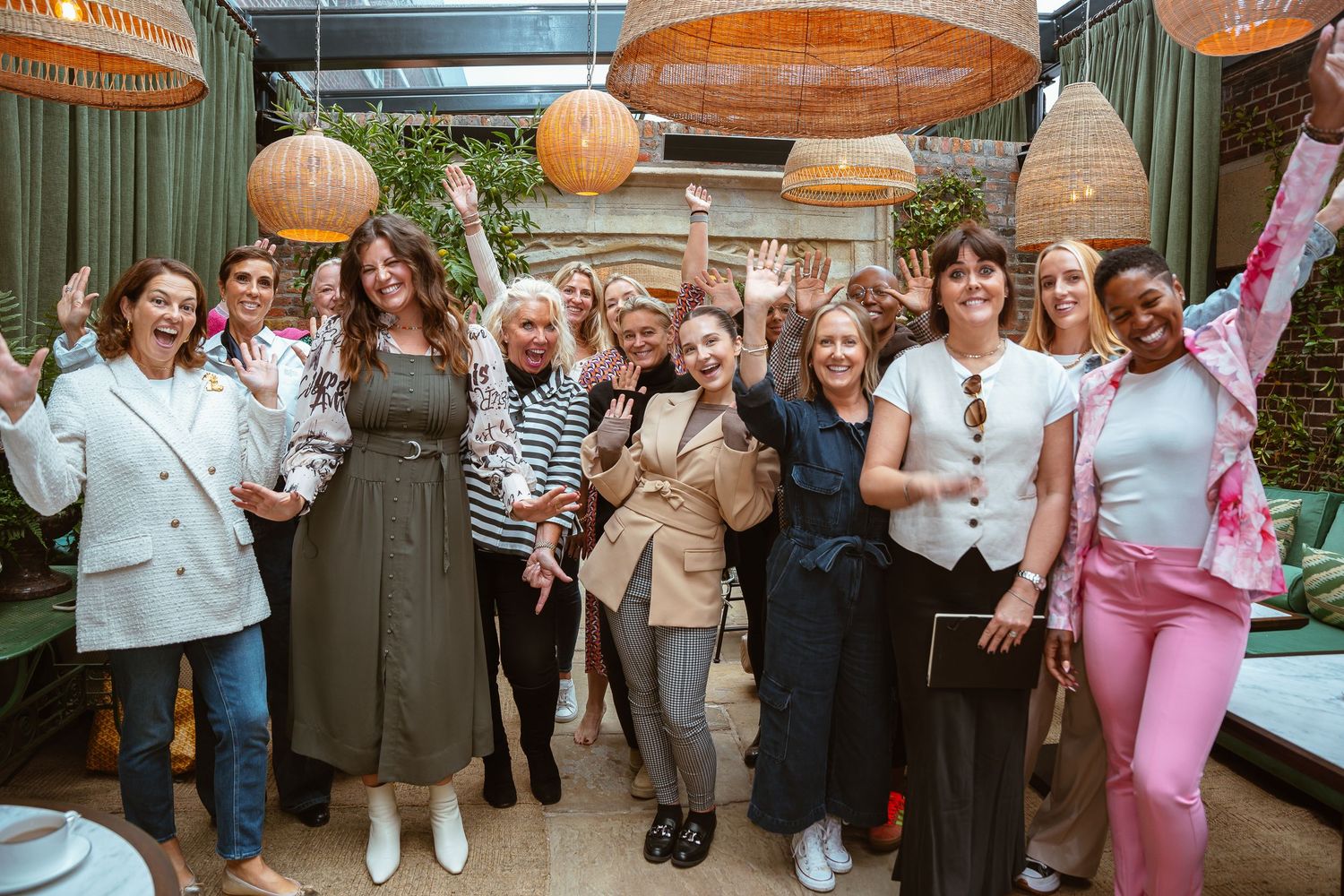 Group photo of event attendees gathered under decorative orange lanterns.