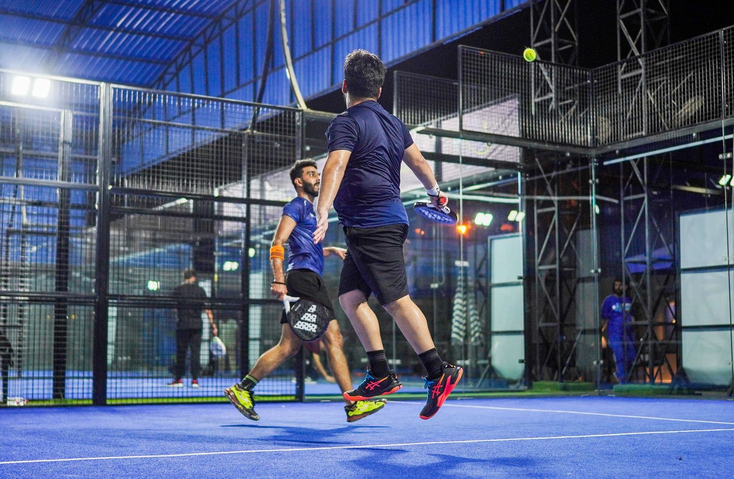 Two players in air chasing ball.