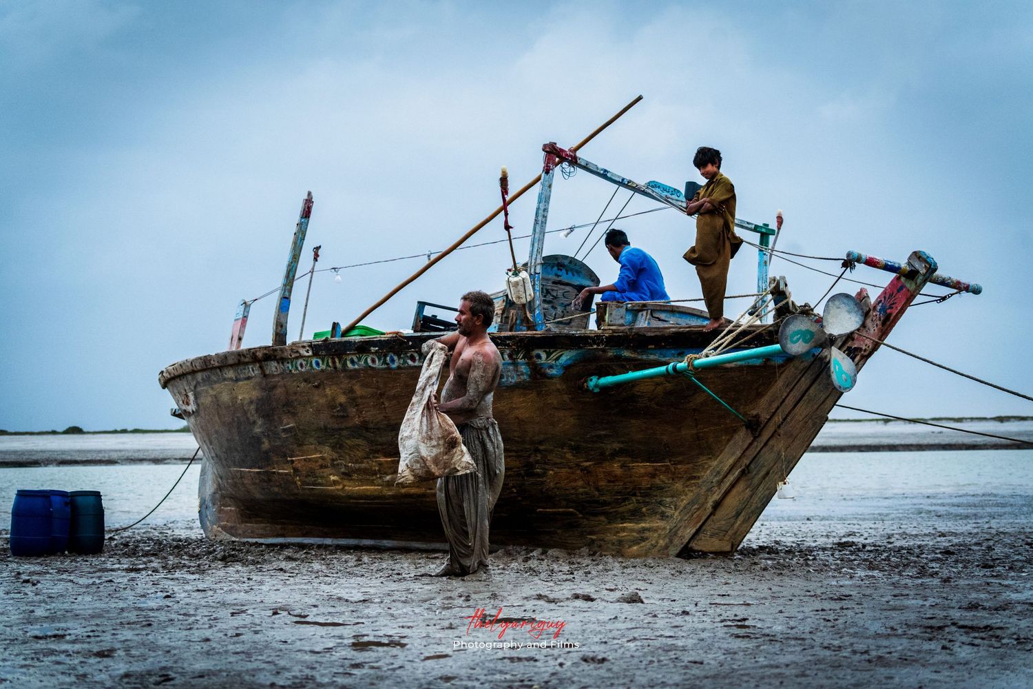 three men with the boat at the seashore.