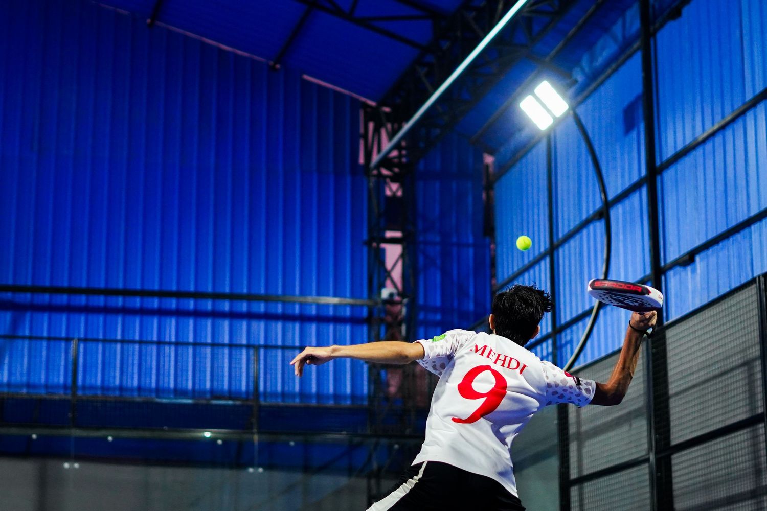 Boy playing padel at the padel club.