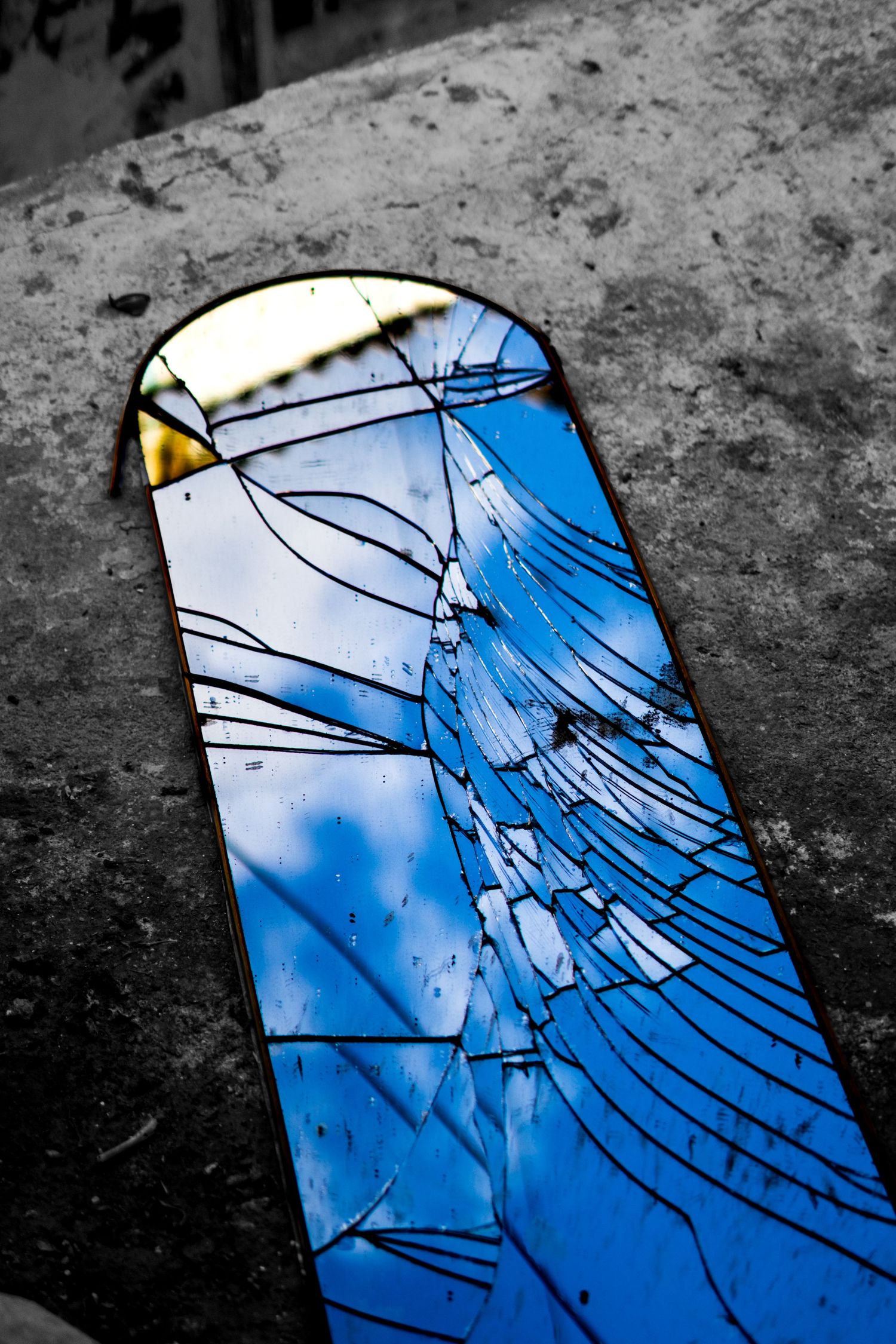 A cracked mirror with a reflection of sky.