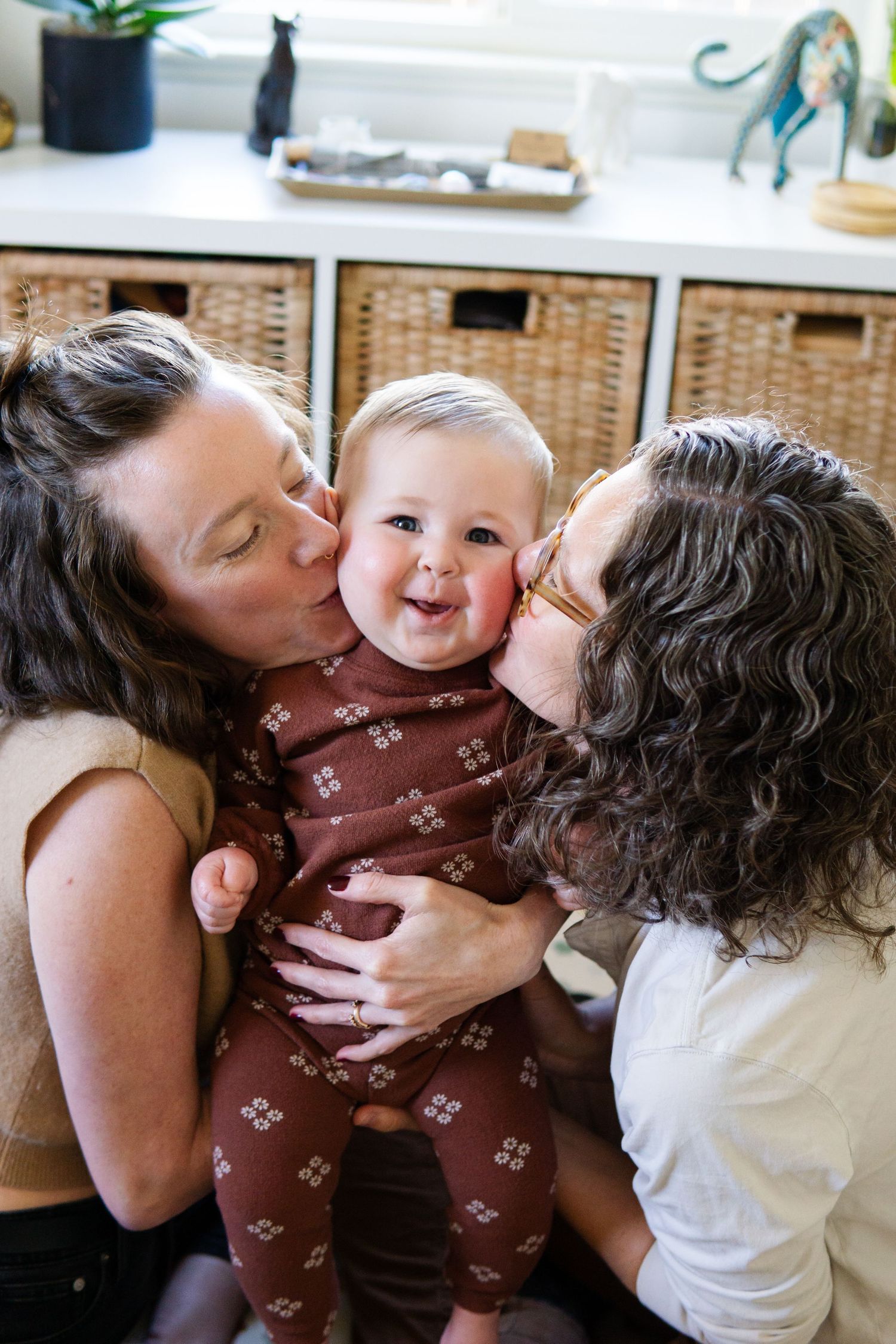 Intimate family moment captured with kisses and cuddles in a cozy home setting.