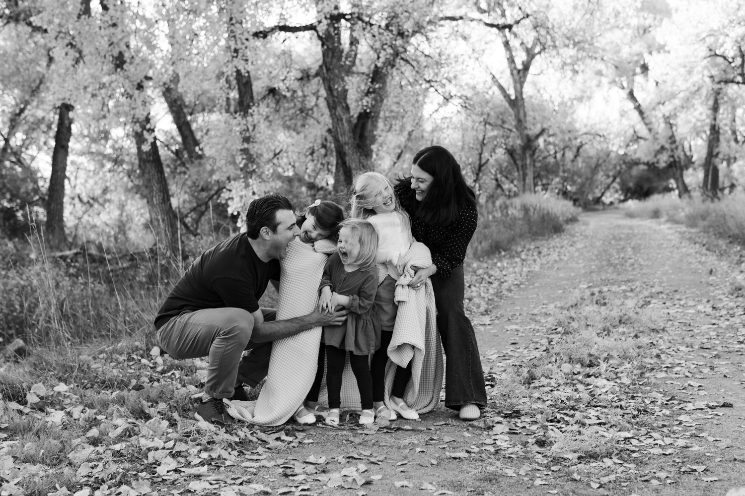 Natural outdoor family photography session among fall foliage and trees.