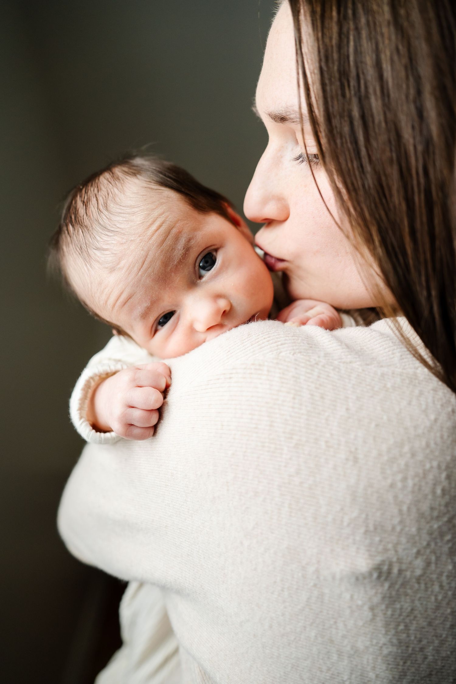 Tender moments between parent and baby in white sweater shown in progression.