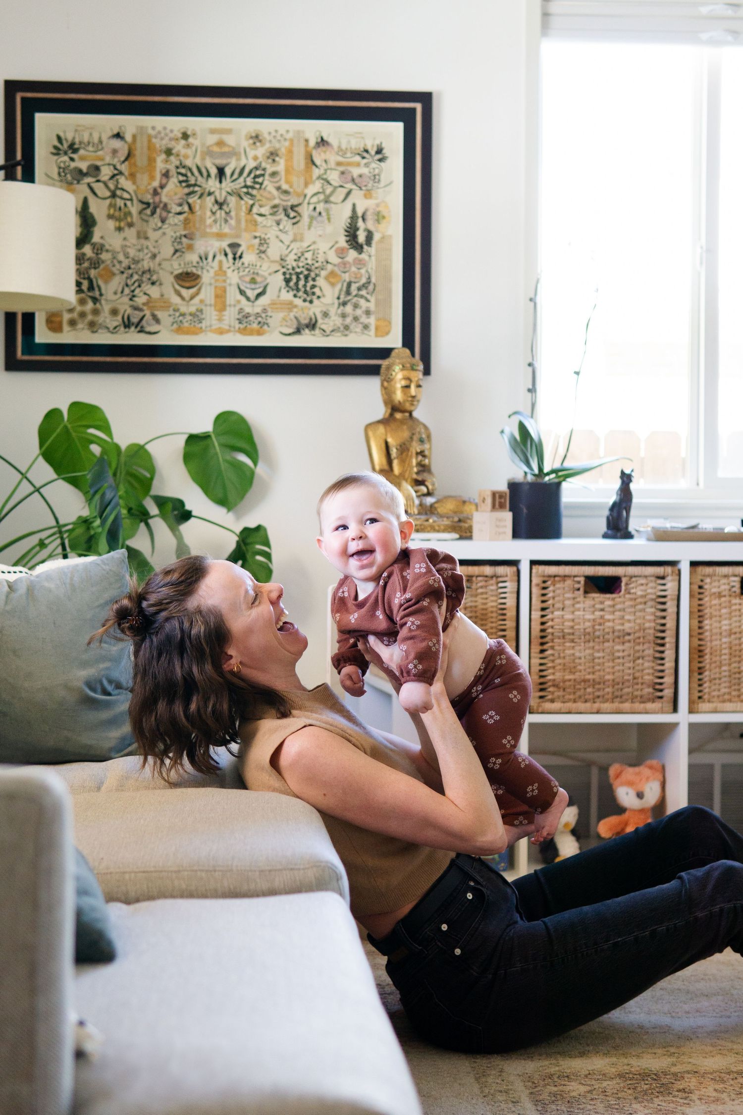 Joyful playtime moment in modern living room with houseplants and framed artwork.