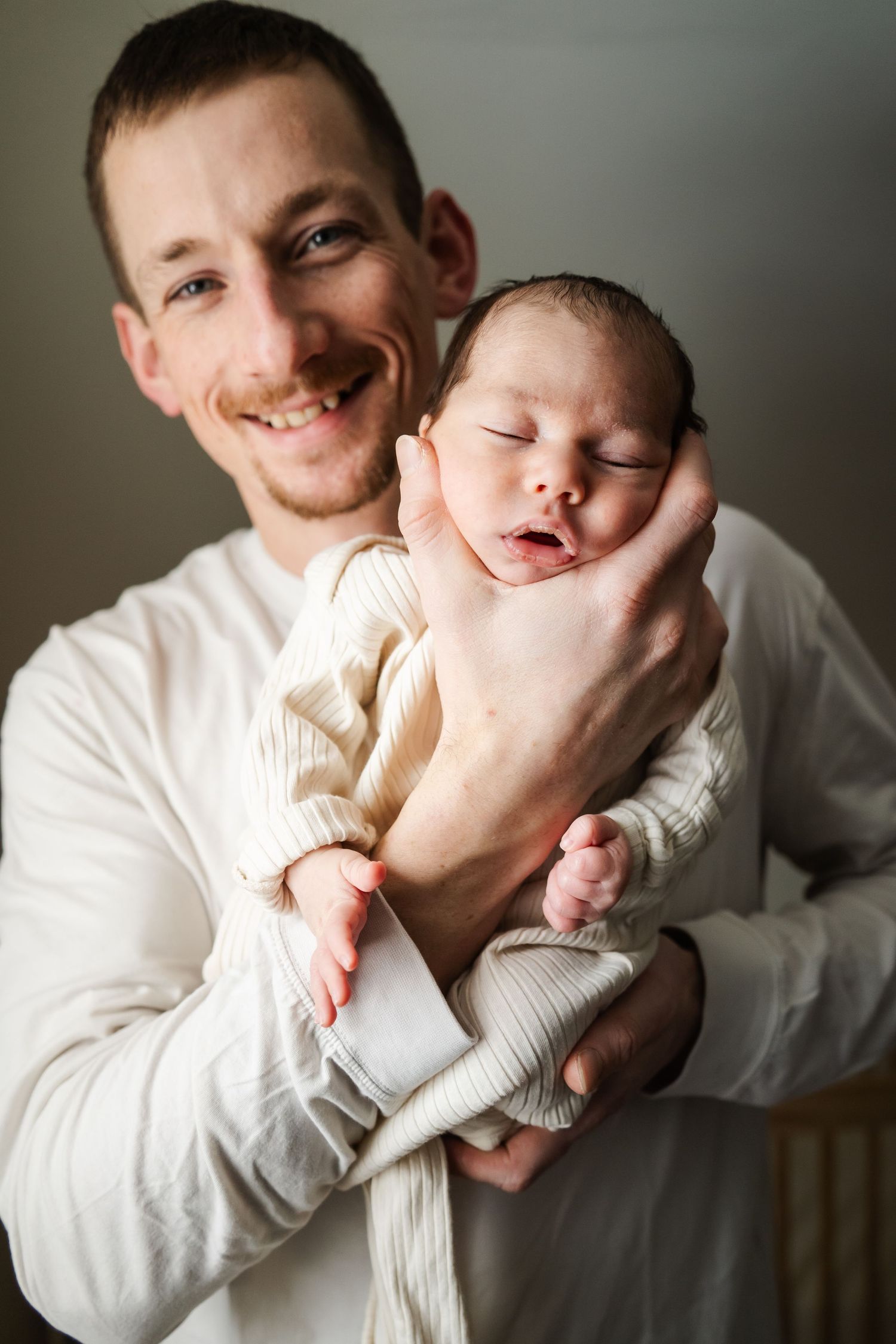 Sweet interaction between parent and infant wearing white shown in multiple frames.