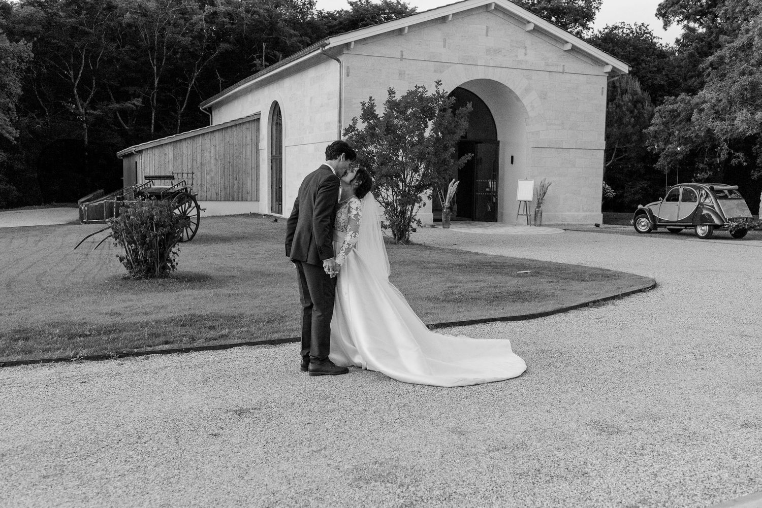 Black and white wedding photos captured outside a rustic building.
