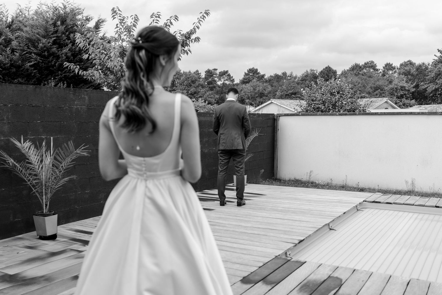Outdoor wedding venue setting with white wooden deck and natural surroundings.