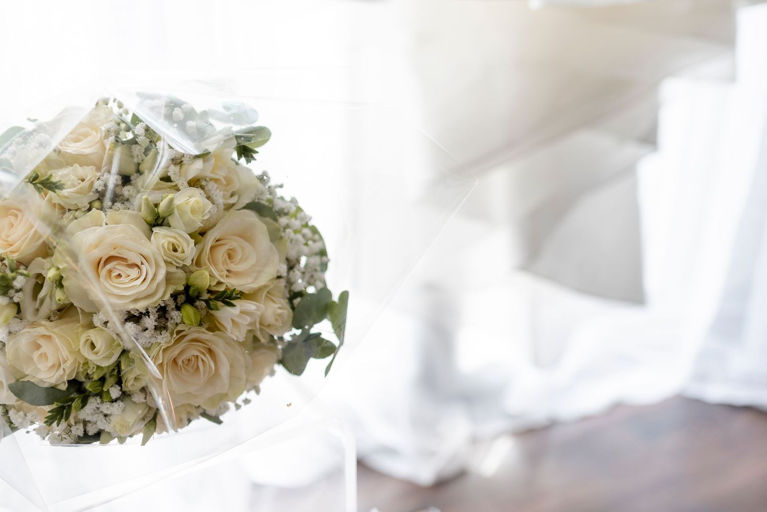 Soft cream-colored roses and floral arrangements in white for a wedding.