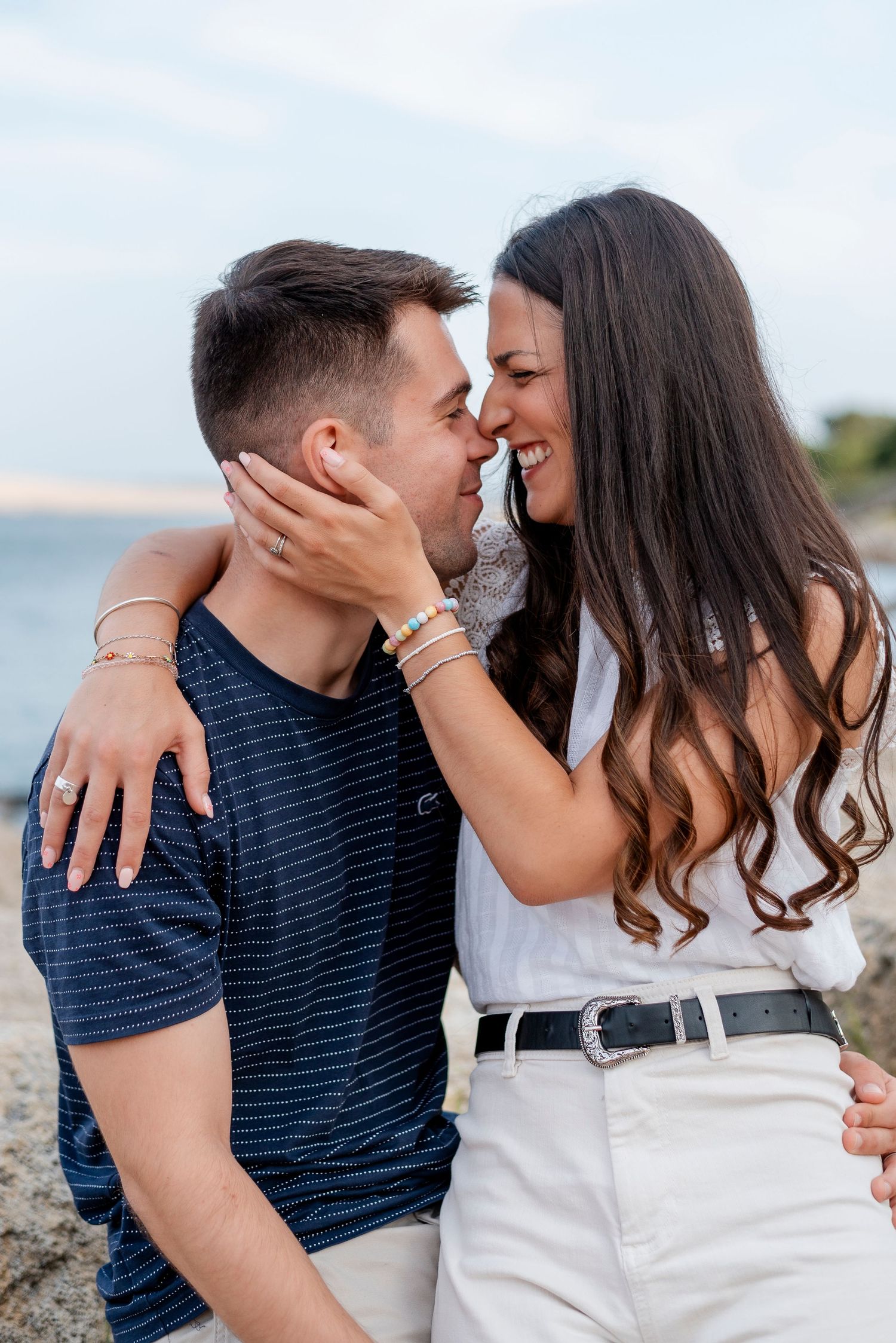 Romantic couple sharing intimate moments and embracing on a beach during a photo session.