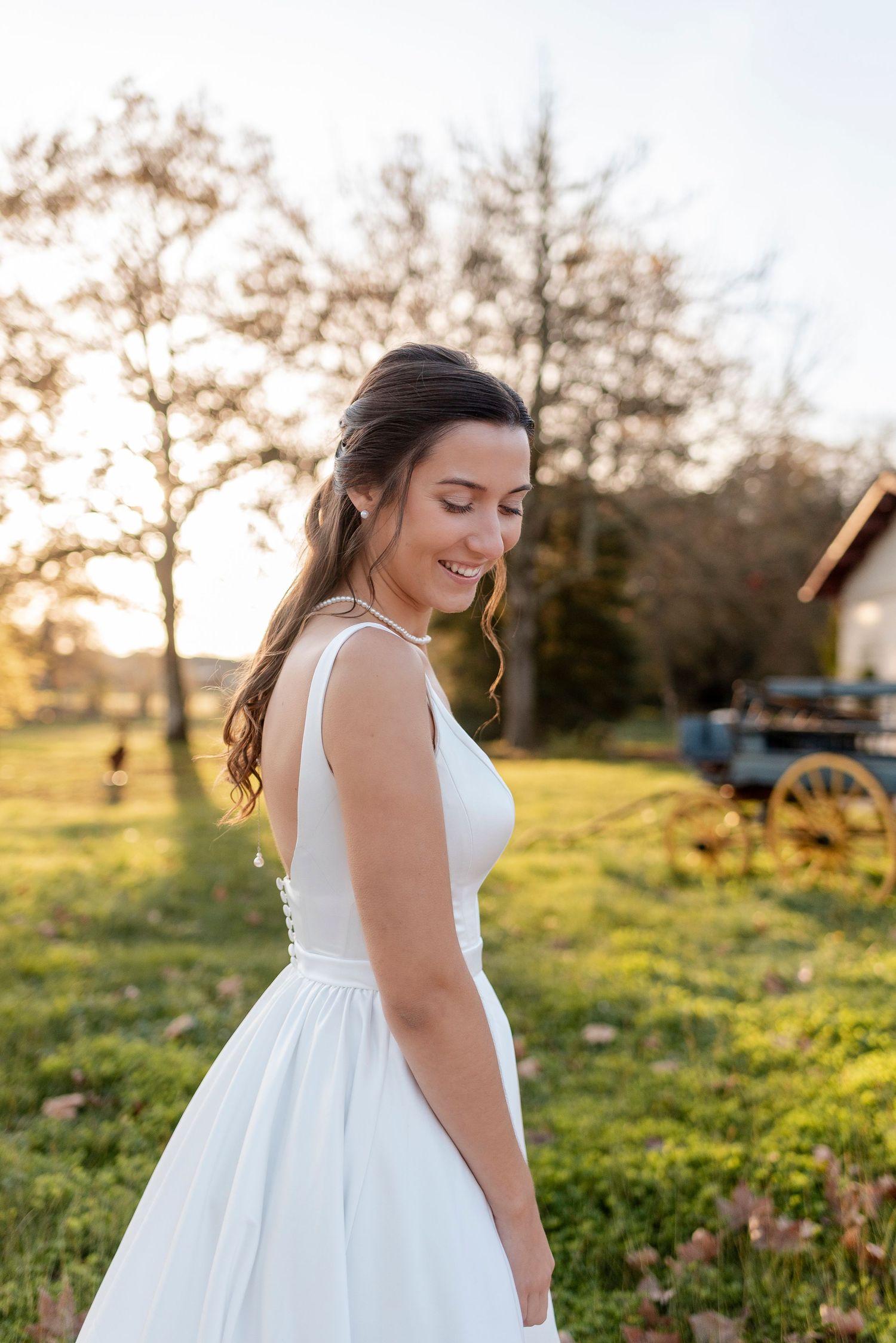 Sunlit outdoor wedding photography session in a grassy field at golden hour.