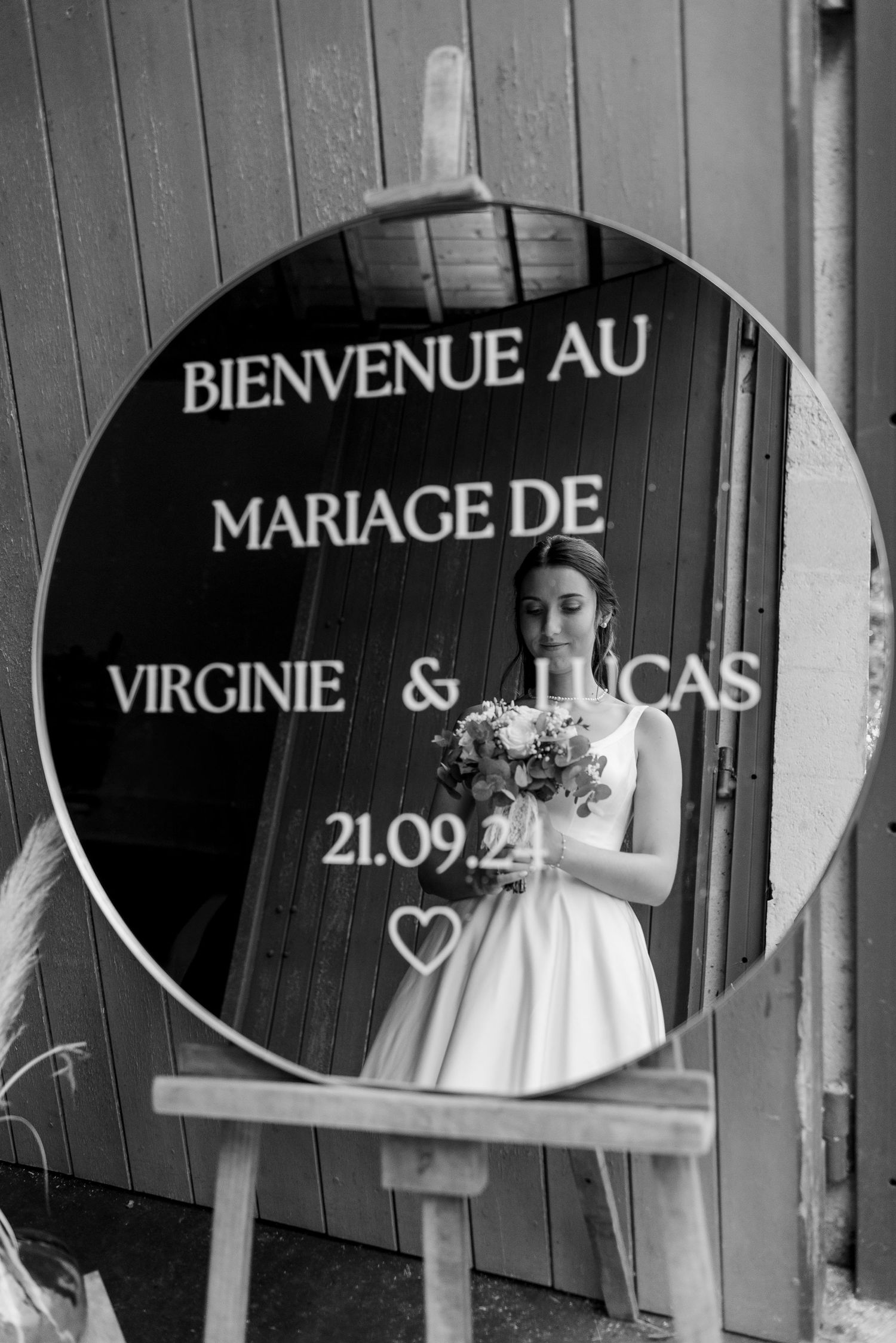 Black and white wedding welcome sign with French text displayed on wooden panels.