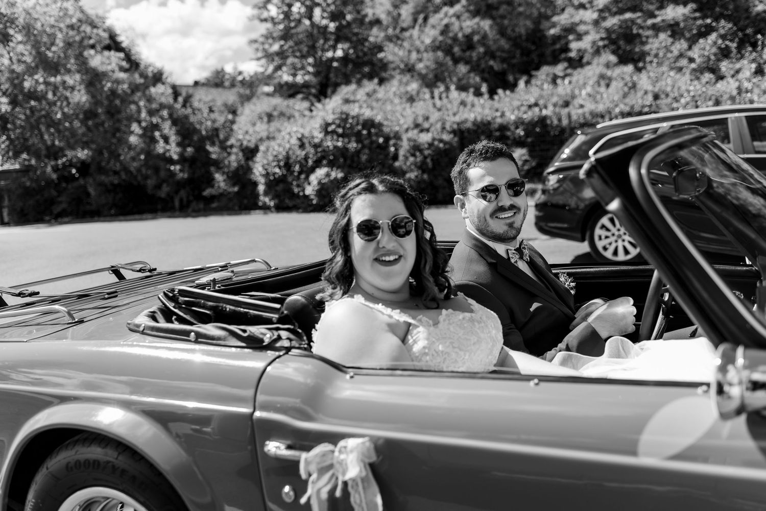 Couple enjoying a ride in a classic vintage convertible car.
