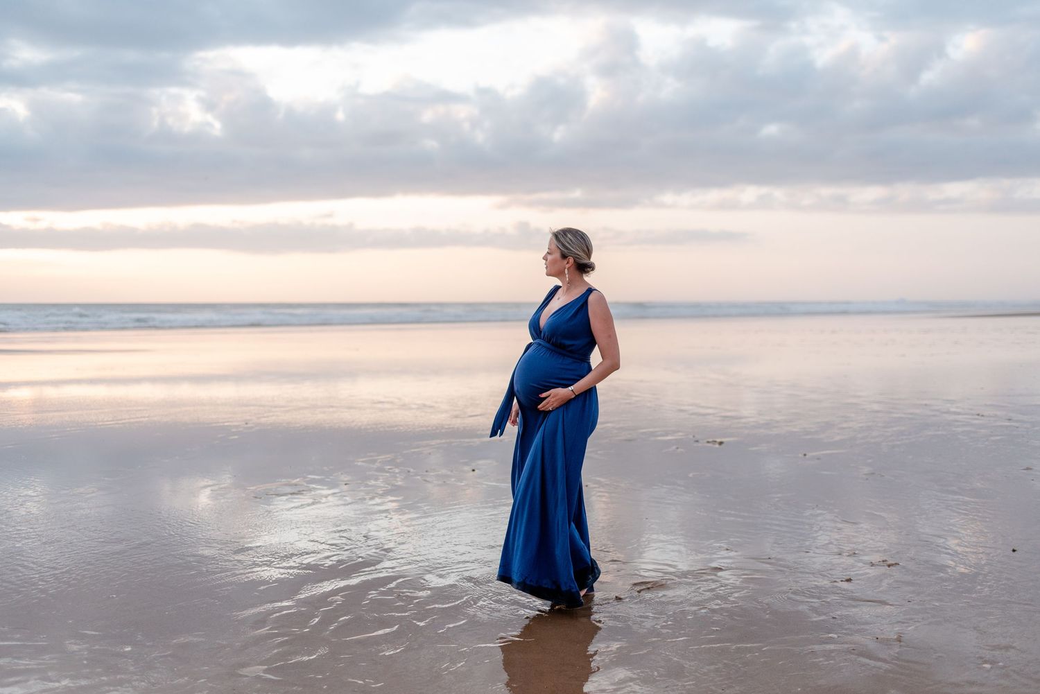 Scenic beach photos showing a figure in blue walking along the shoreline at sunset.