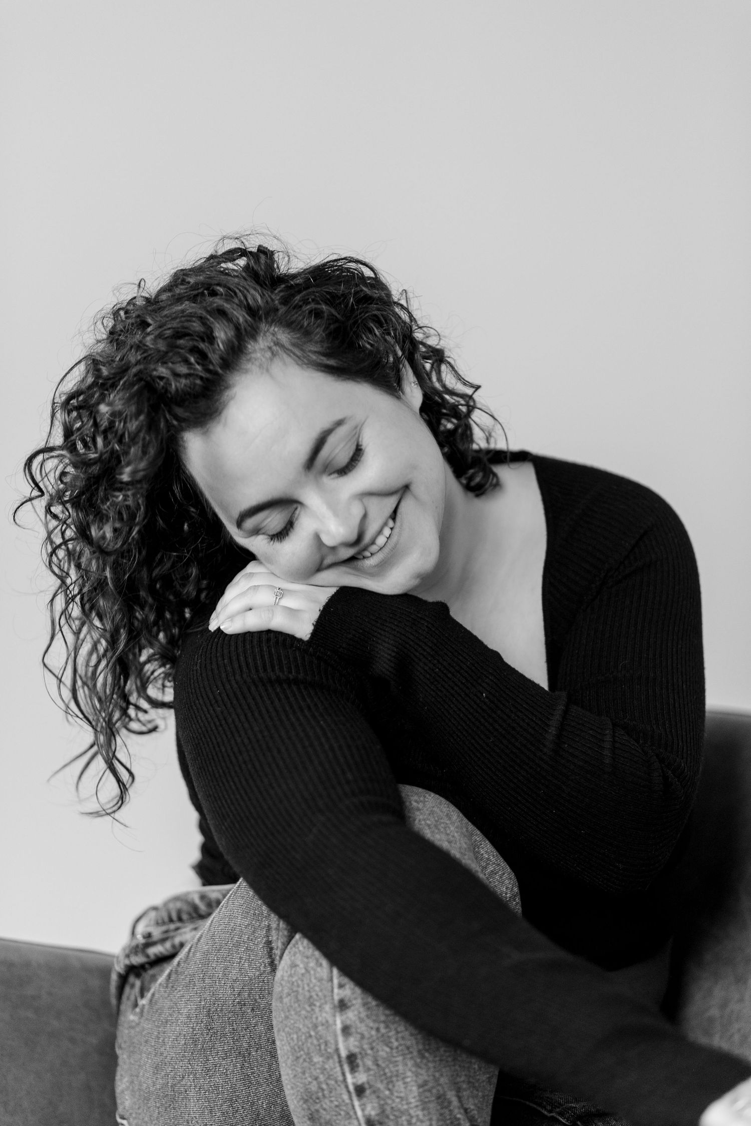 Black and white portrait of person in cozy sweater relaxing on couch.