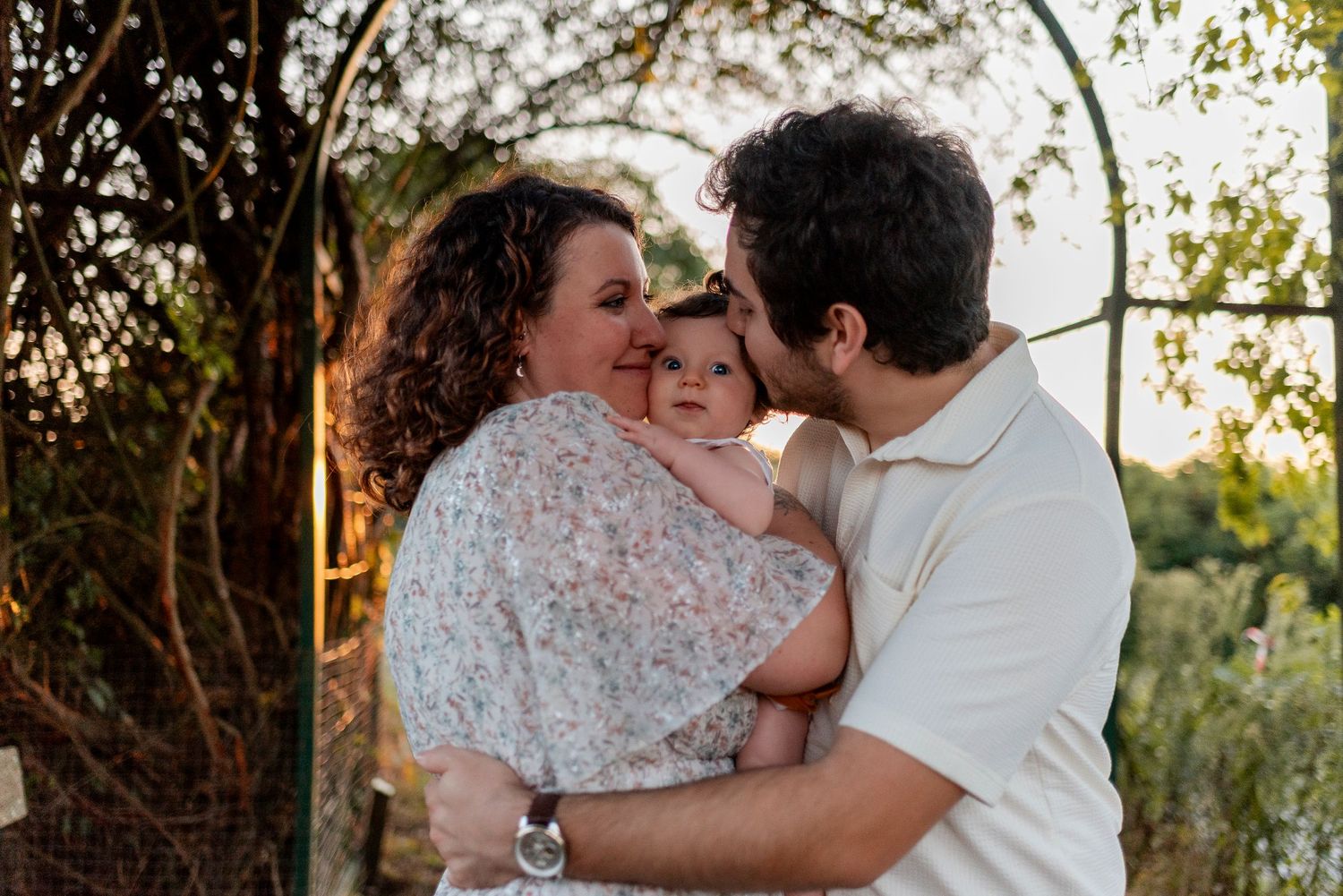 Couple sharing intimate moments during a golden hour photoshoot in a garden setting.