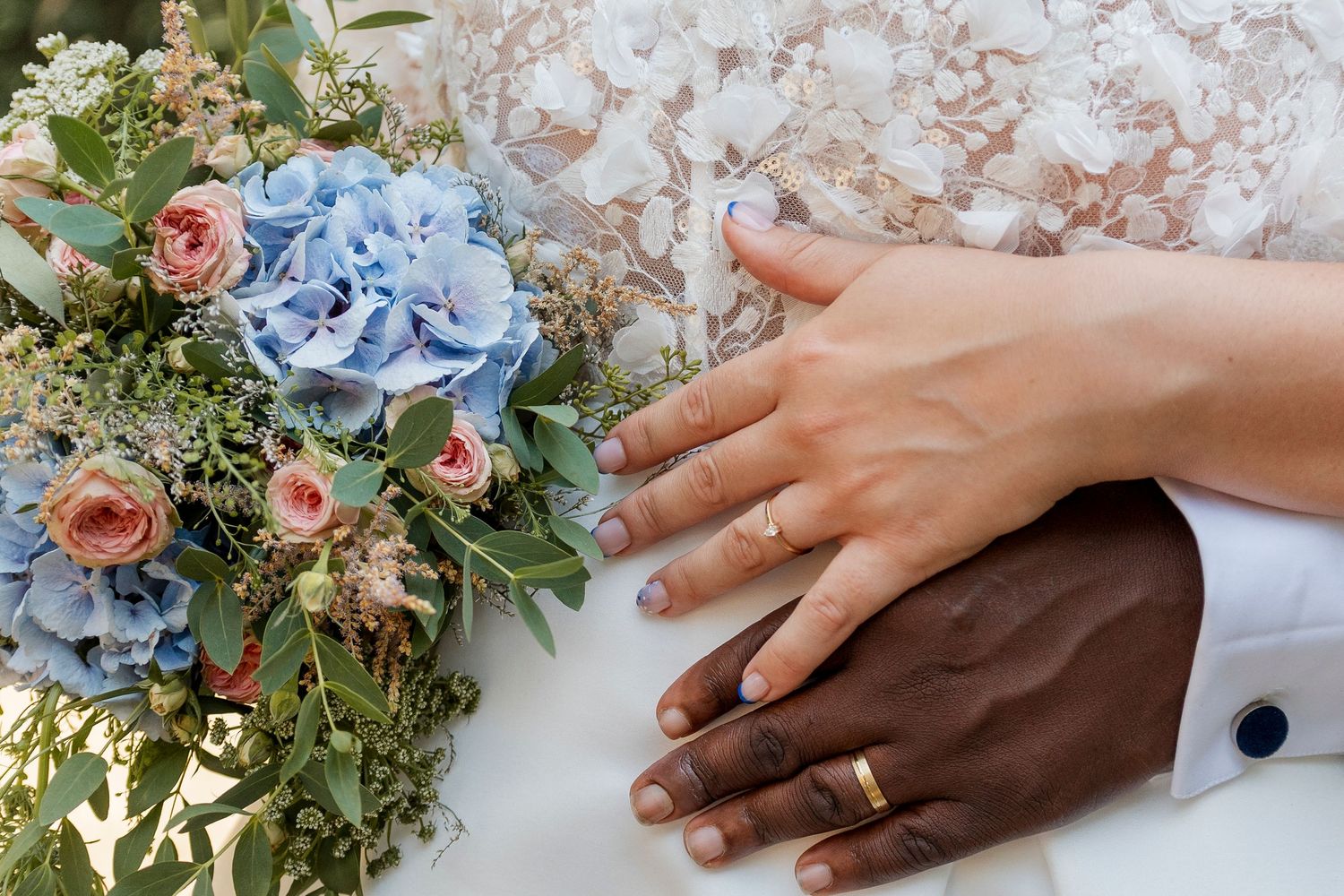 Wedding rings and floral details with blue and pink blooms.