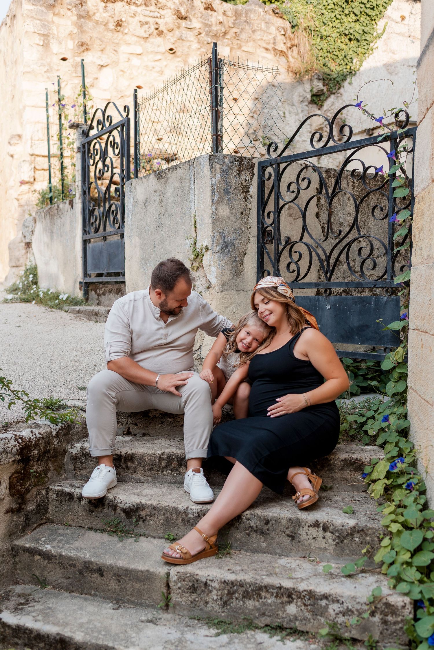 Expecting couple sharing playful moments on rustic stone steps.