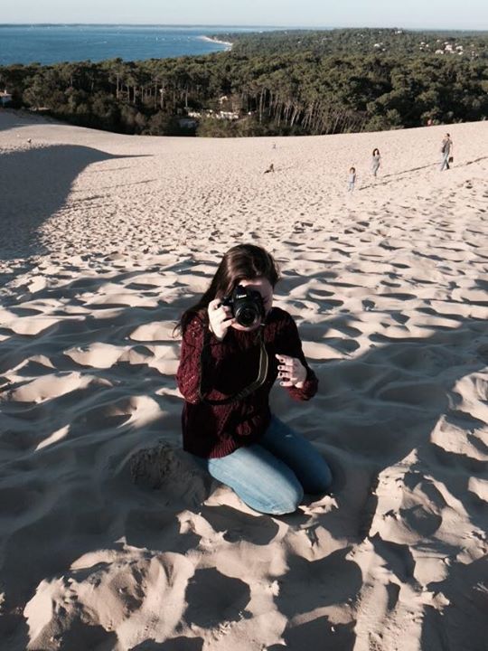 Series of photos showing someone rolling down large sand dunes on a sunny day.