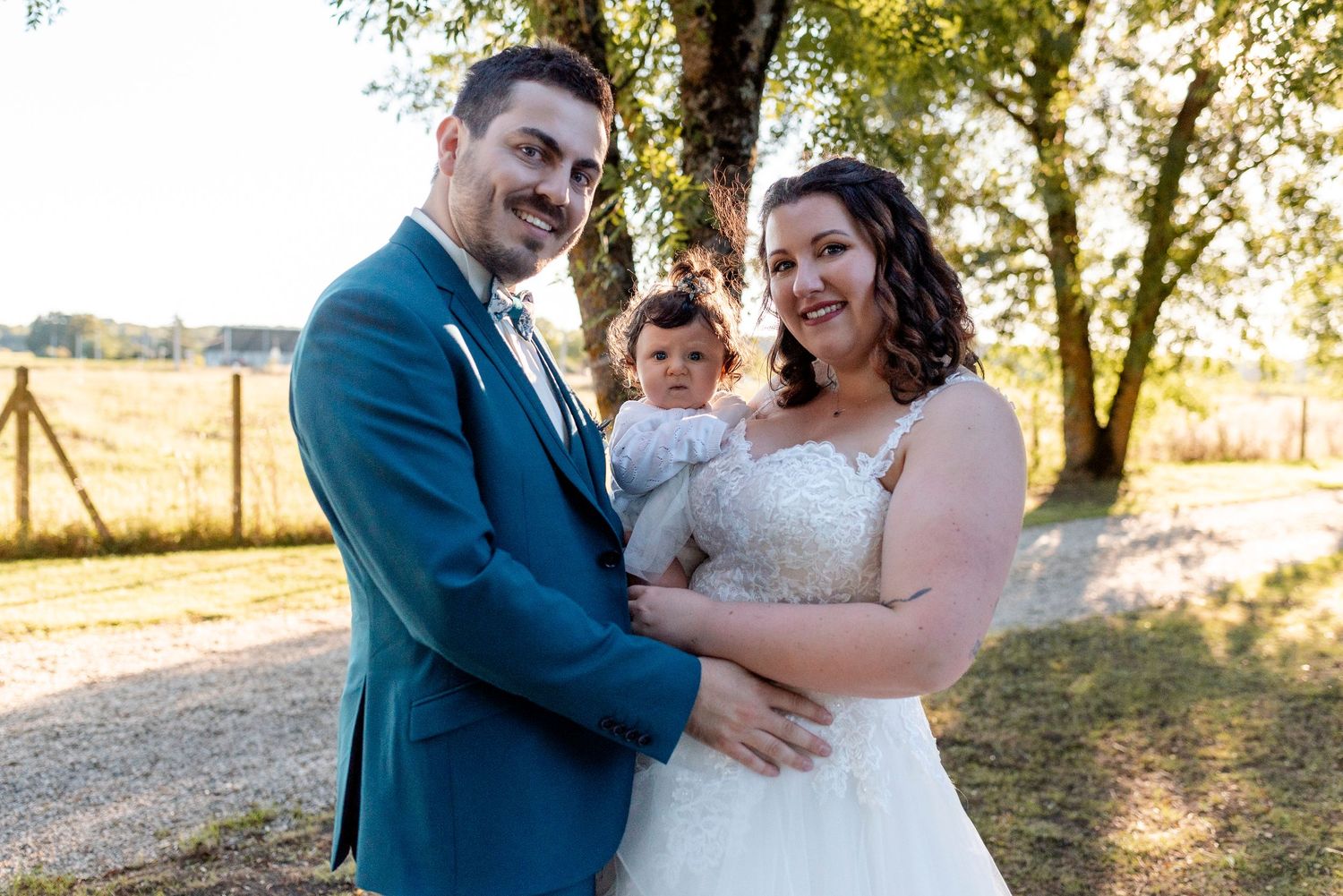 Newlyweds sharing a romantic moment in a golden sunset field.