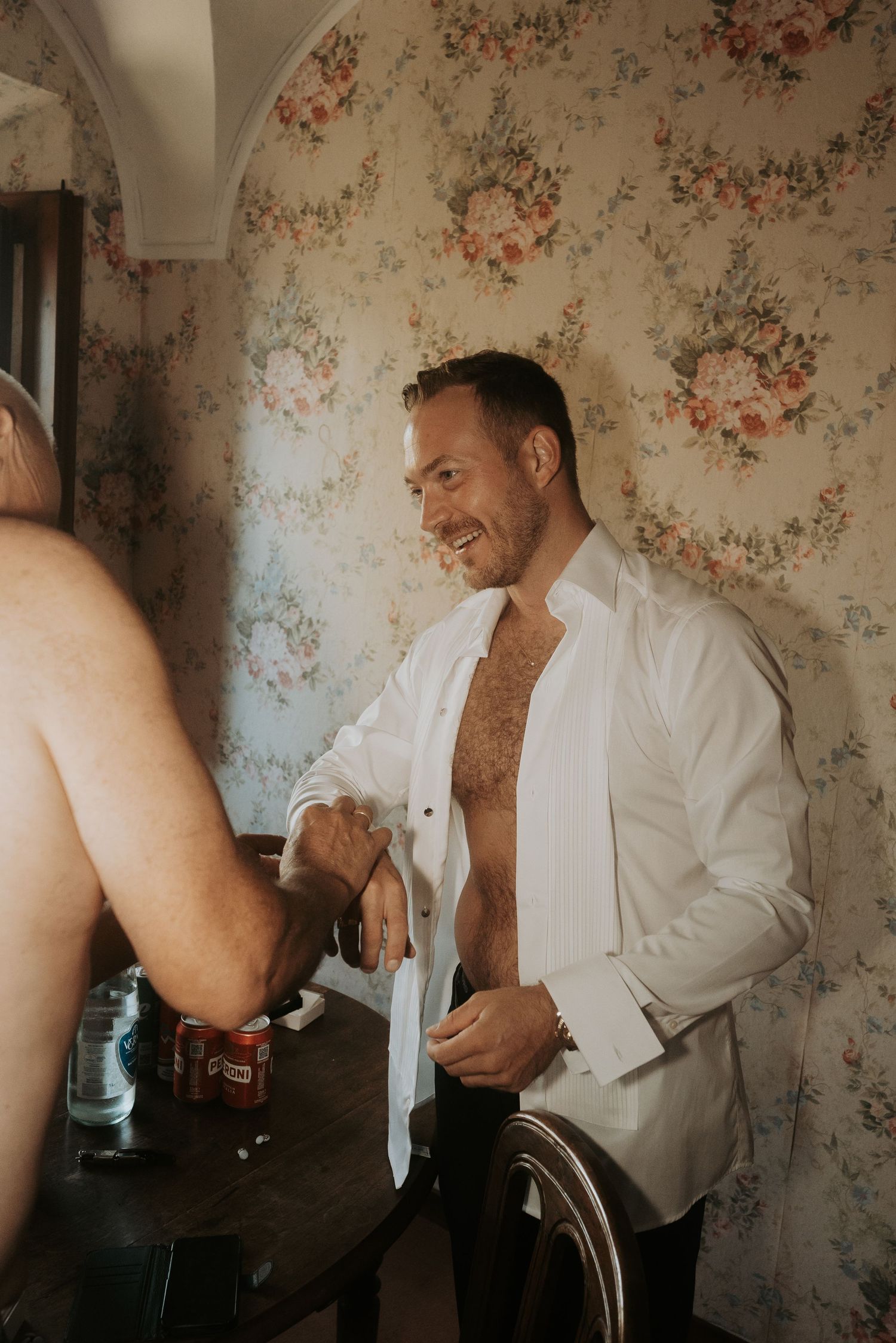 A sequence of getting ready moments showing someone adjusting formal attire against floral wallpaper.