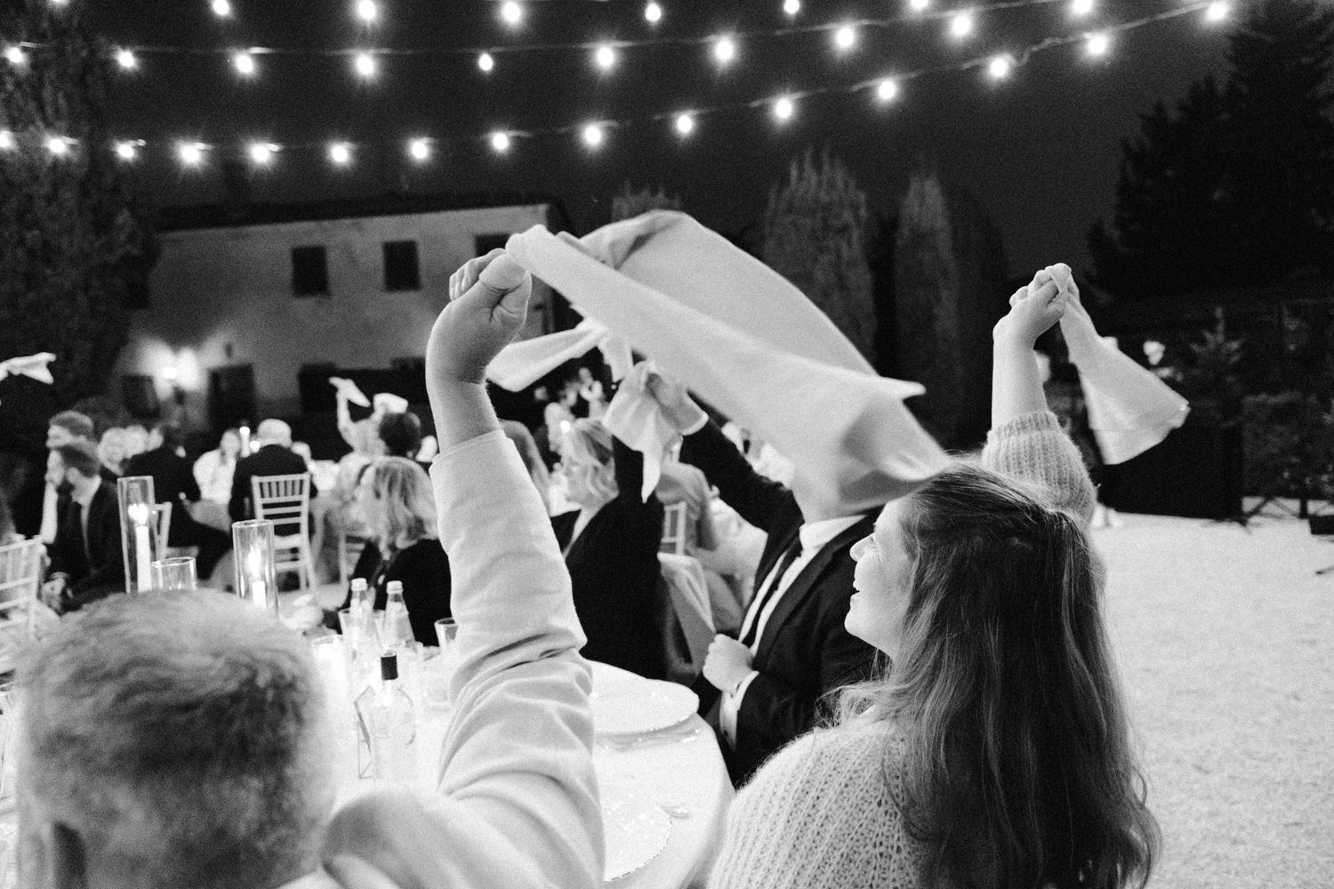 Wedding celebration at night with string lights creating a magical atmosphere.