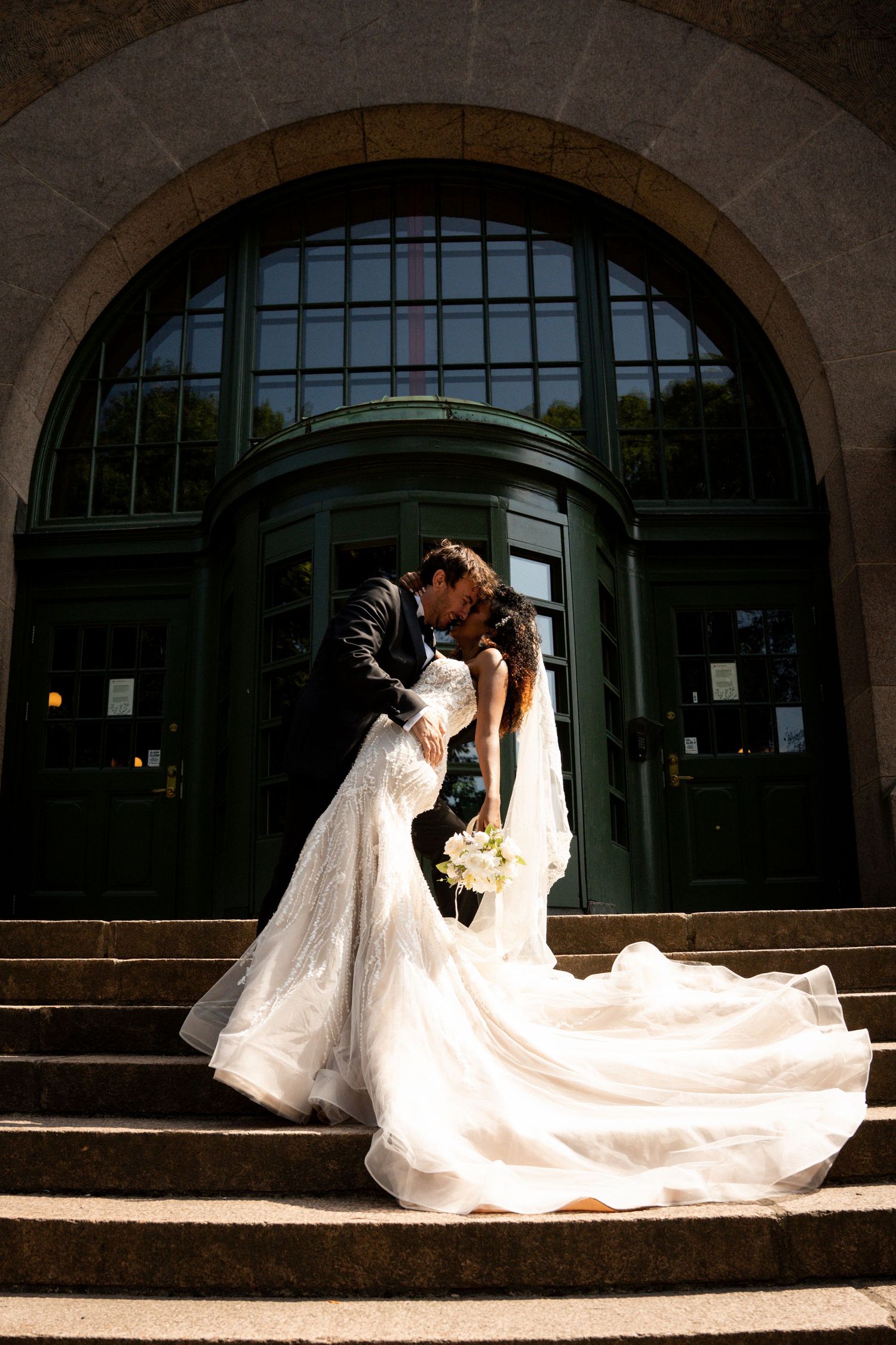 Dramatic wedding poses under stone archways with flowing white dress and veil.