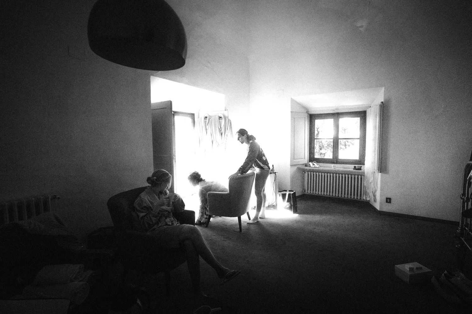 Moody black and white interior shot of a room with window light creating dramatic shadows.