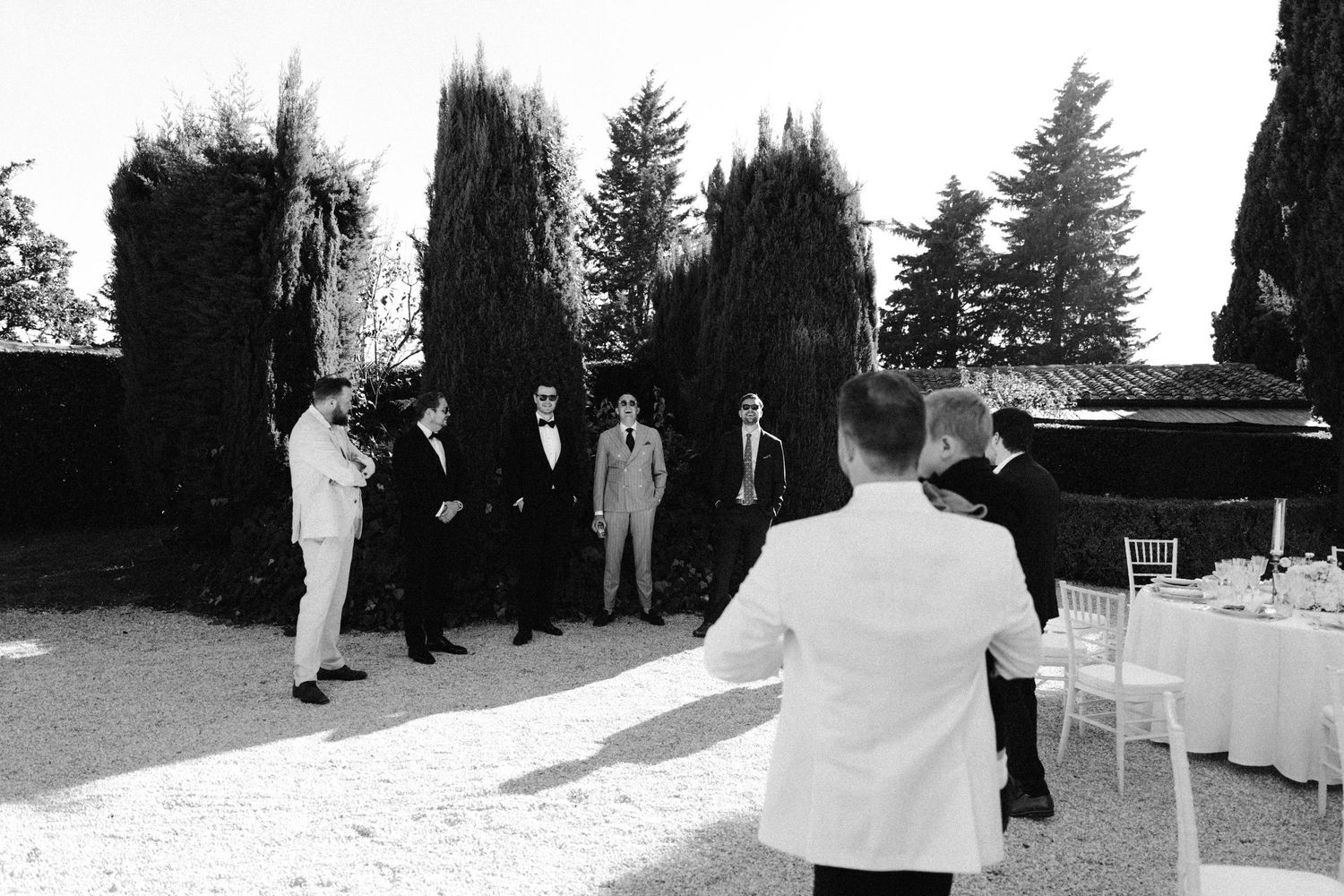 Outdoor wedding venue setup with chairs and trees in the background.