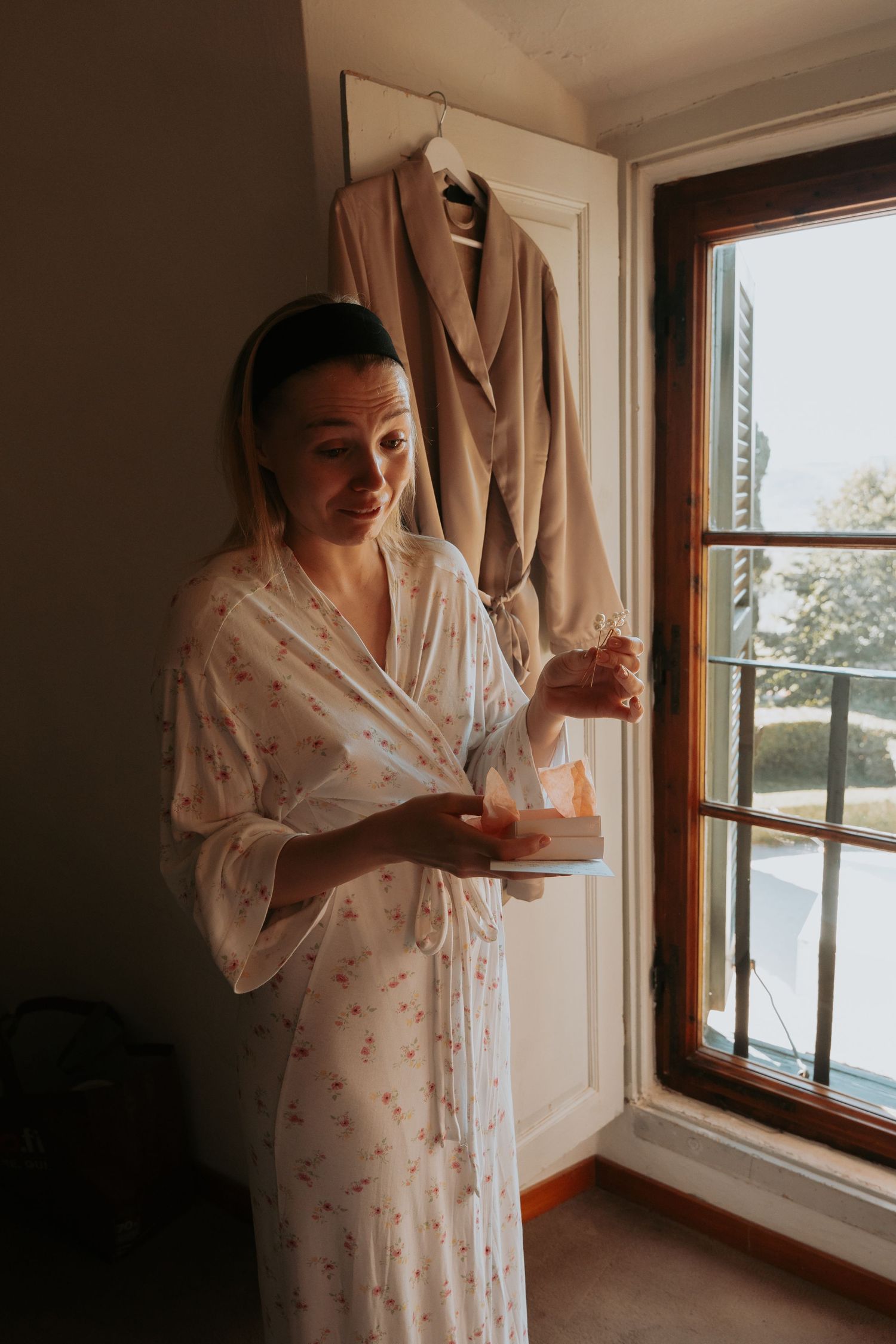 Morning light streams through a window into a room with cream-colored curtains.