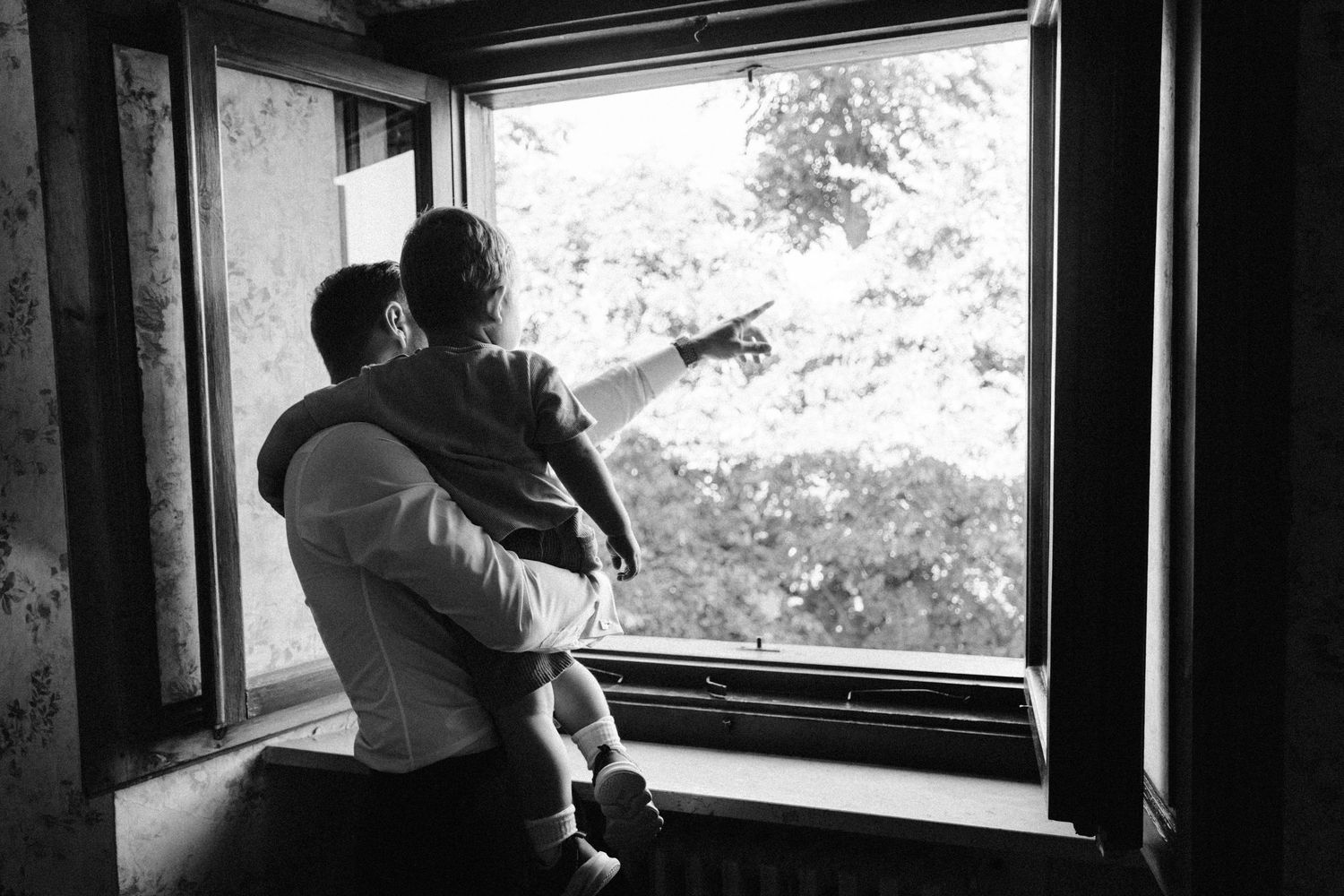 Silhouettes framed against large windows in an atmospheric interior setting.