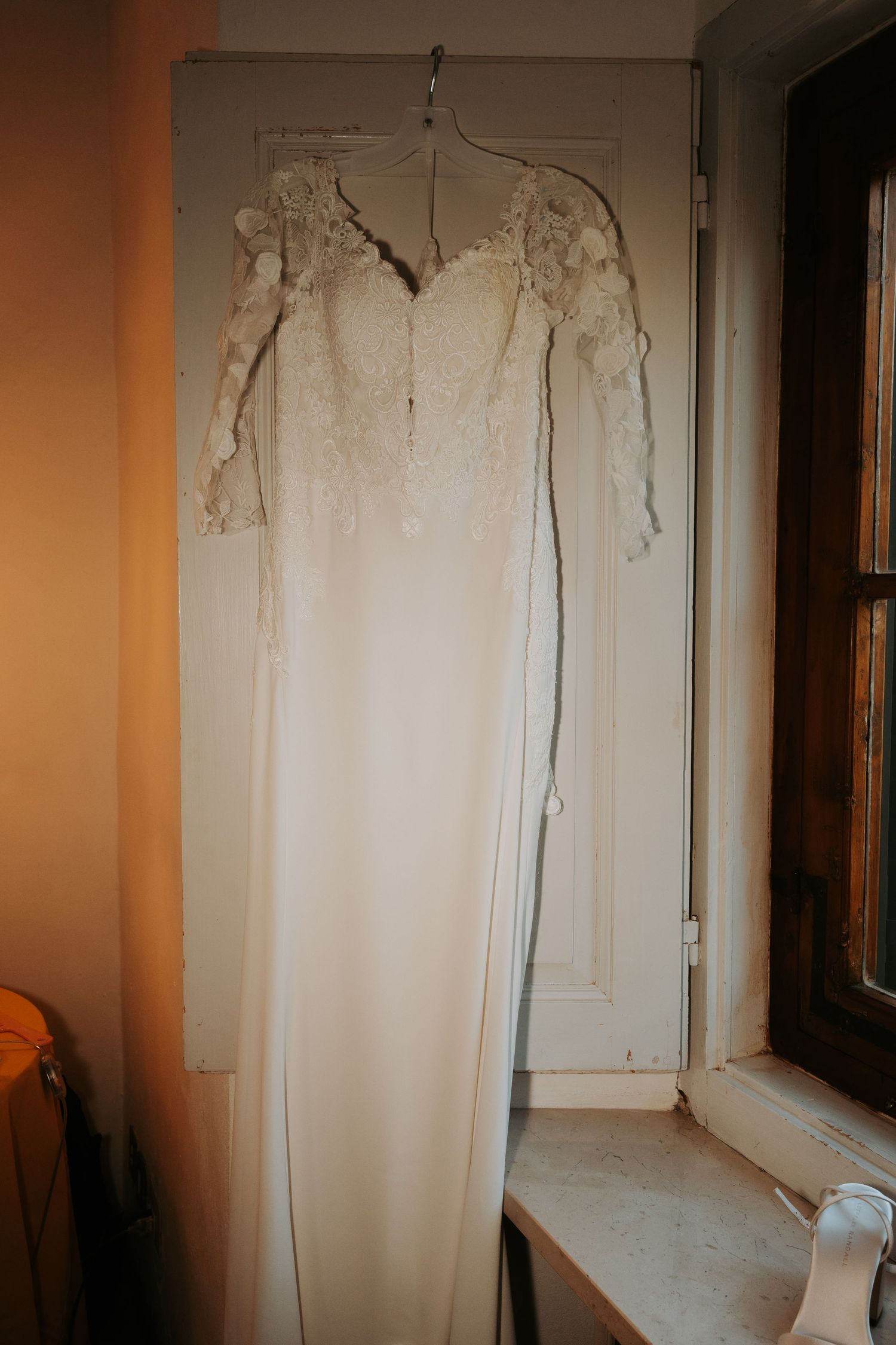 Vintage white lace curtains hanging in front of a window with warm lighting creating a romantic atmosphere.