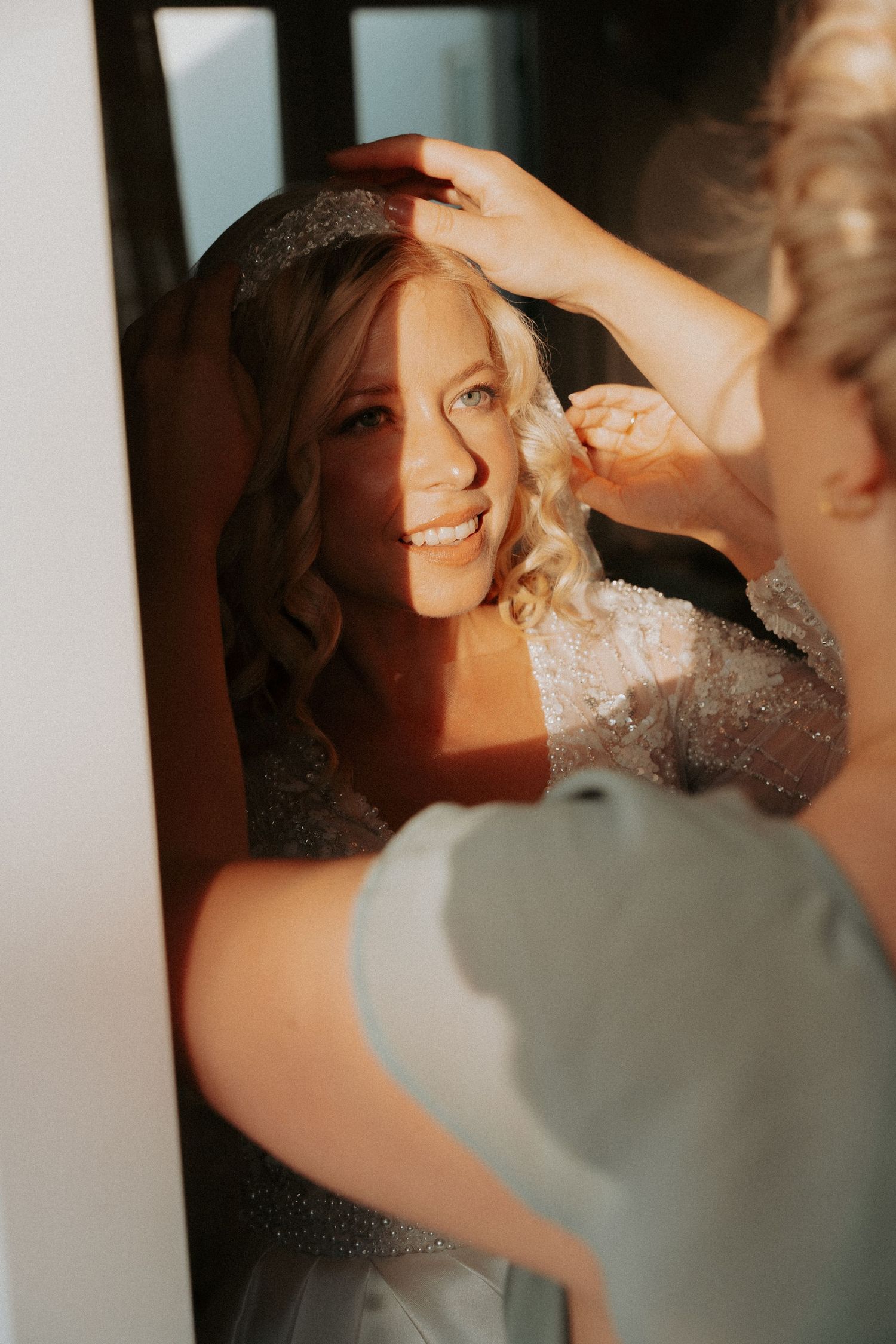Sunlit preparation moment with bridal accessories and golden light.