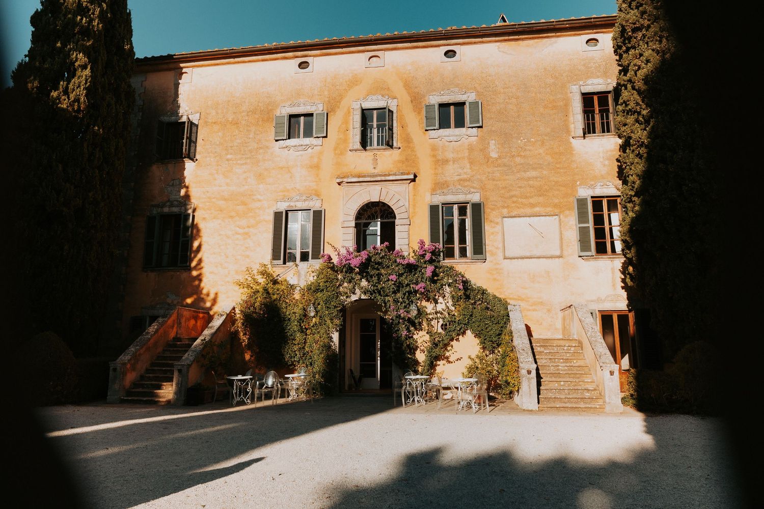 A sun-drenched Italian villa with classic architecture and flowering balconies.