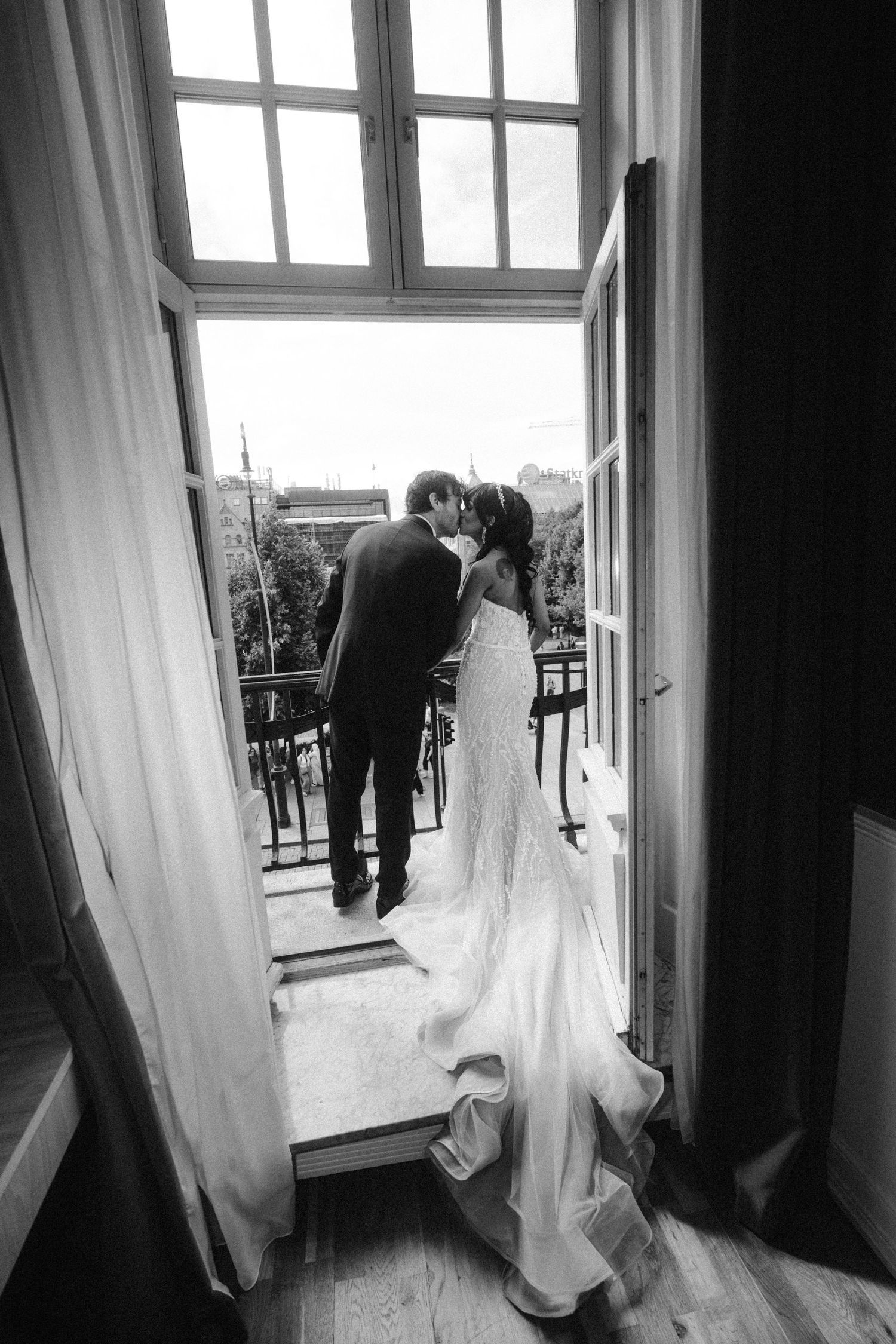 Black and white photos of wedding dress flowing near window with curtains.