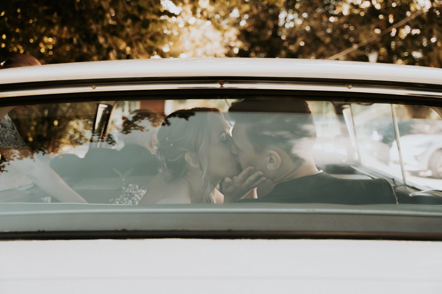 Silhouette of a couple sharing a romantic moment inside a vintage car.