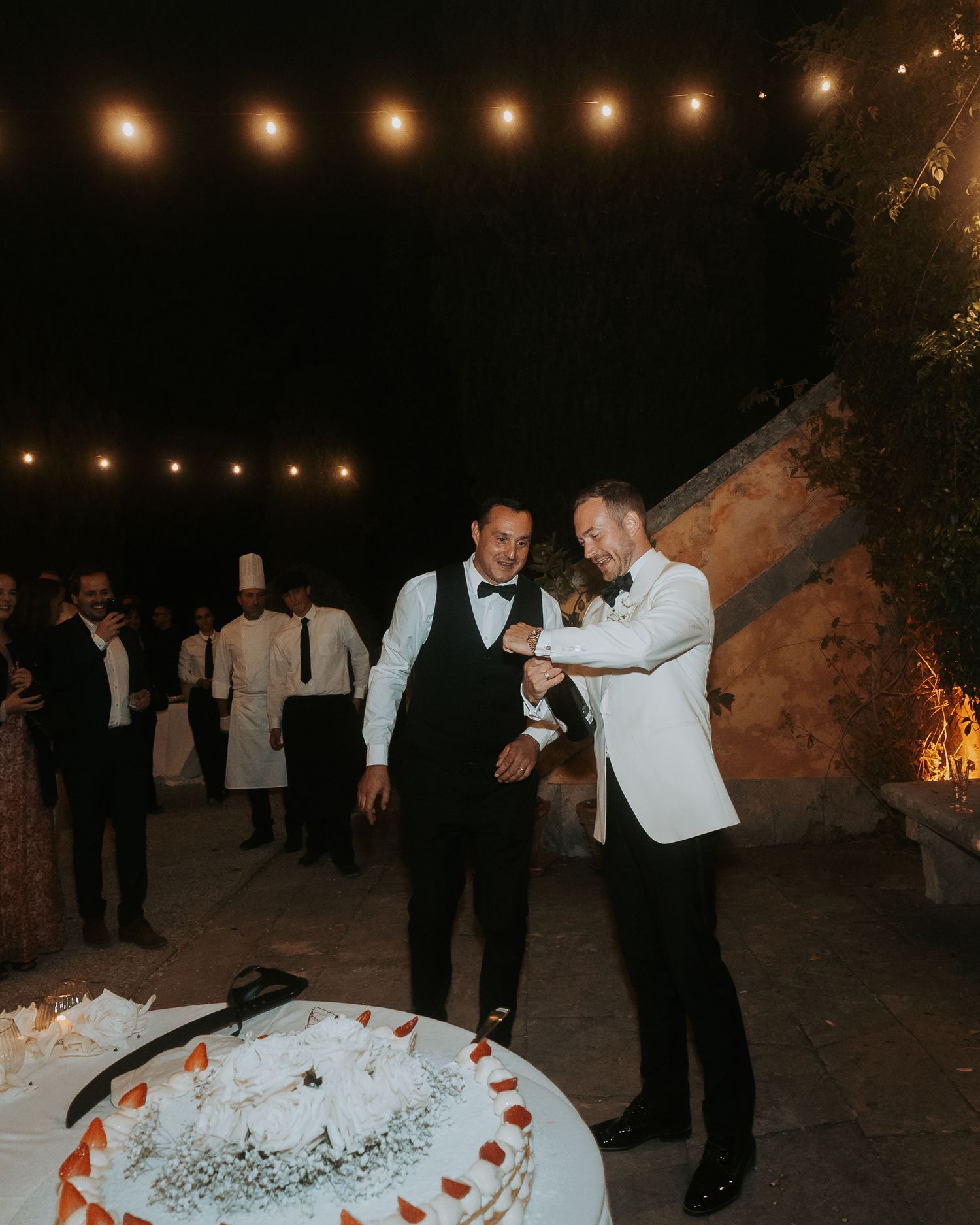 Wedding reception at night with string lights creating a romantic ambiance.