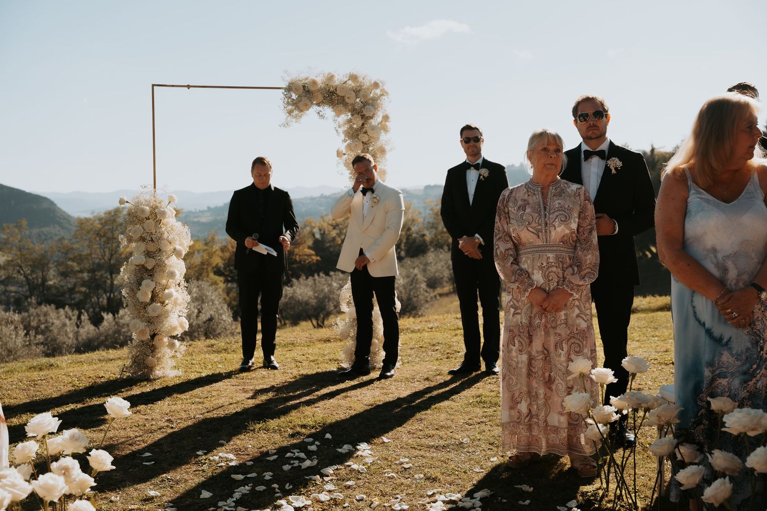 Wedding party members walking along a scenic mountain path during an outdoor celebration.