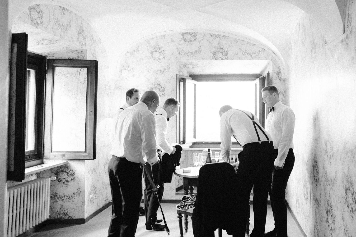Black and white photos showing preparation moments in a room with natural window light.