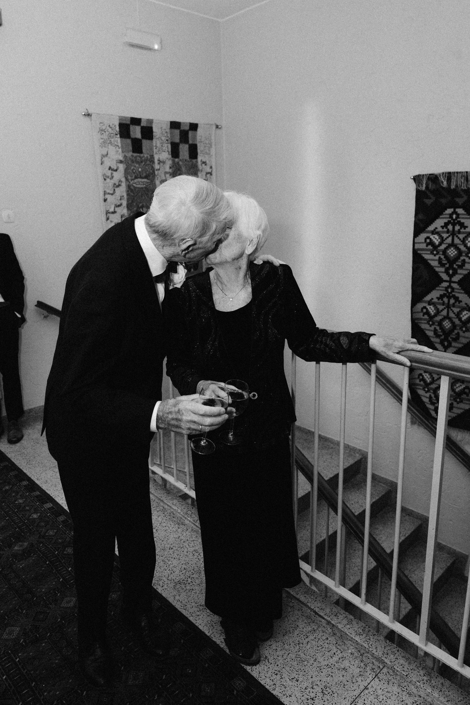 Black and white photos showing intimate moments in a hallway with formal attire.