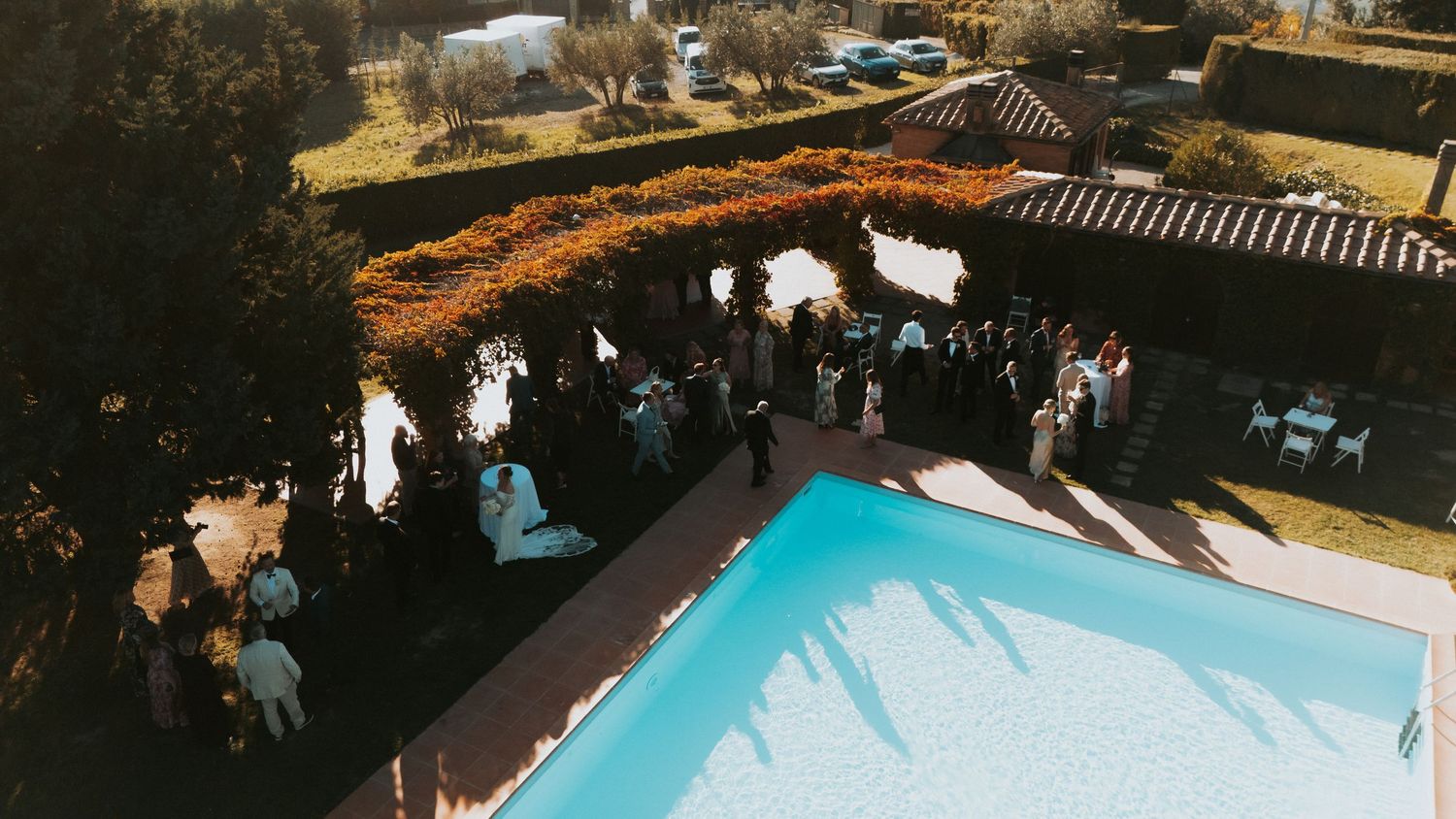 Aerial view of outdoor wedding reception with swimming pool.