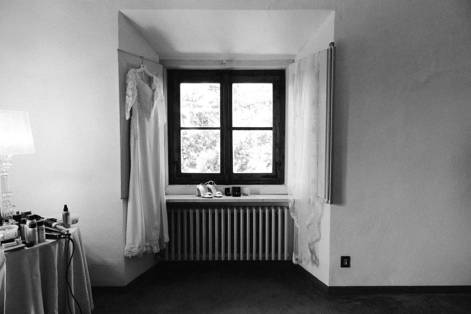 Minimalist black and white interior hallway with window and radiator creating stark geometric lines.