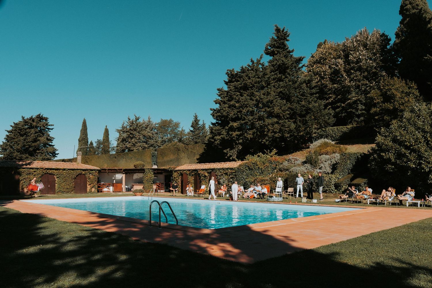 Scenic outdoor venue with swimming pool and mountain views surrounded by tall pine trees.