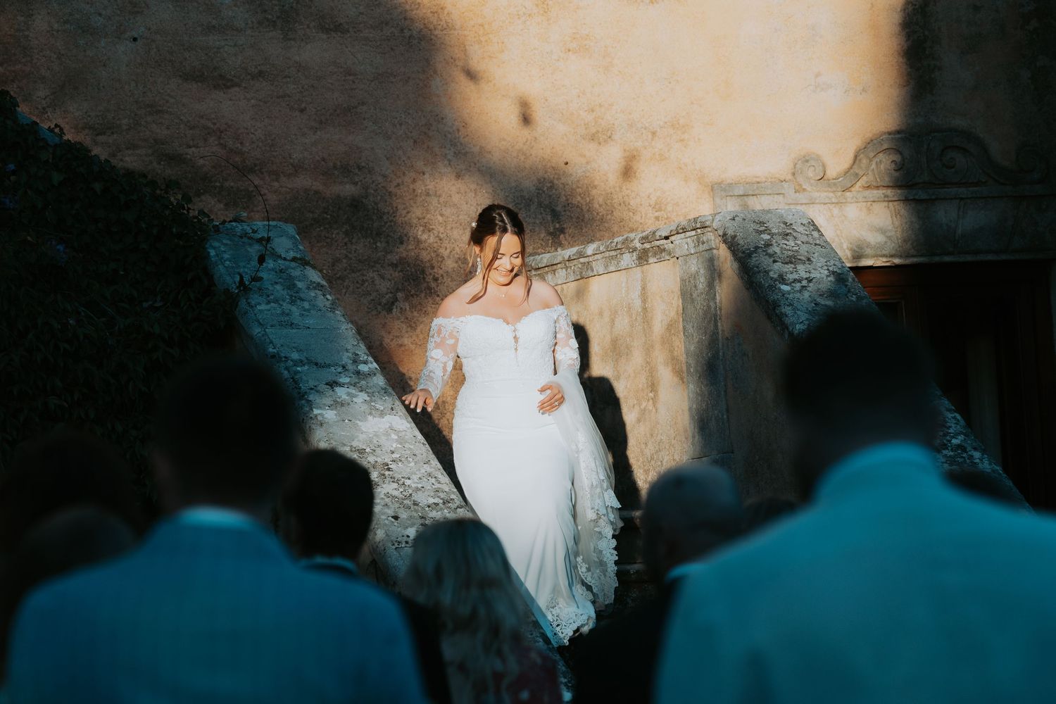 Elegant outdoor wedding ceremony setup against a weathered stone wall backdrop.