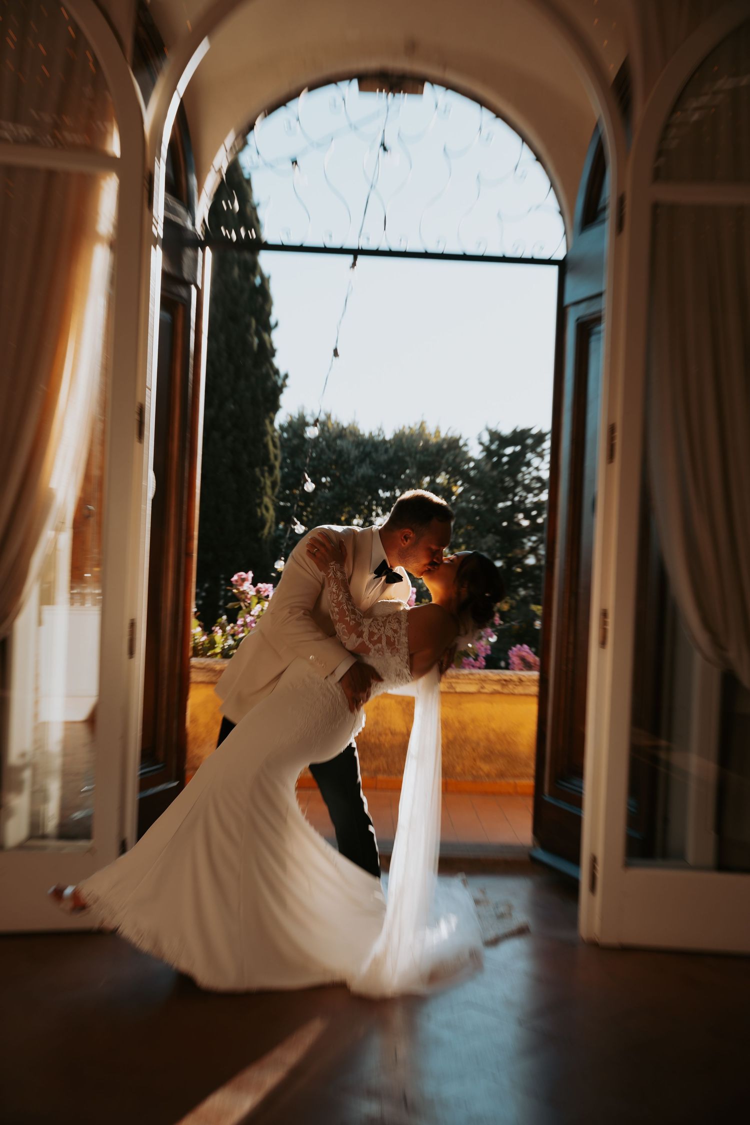 Romantic dance silhouettes framed by elegant archways at sunset.